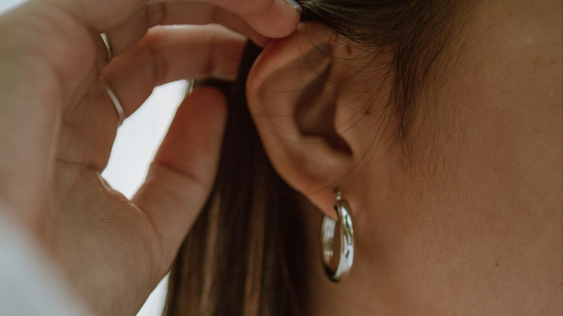 woman in white shirt wearing gold necklace