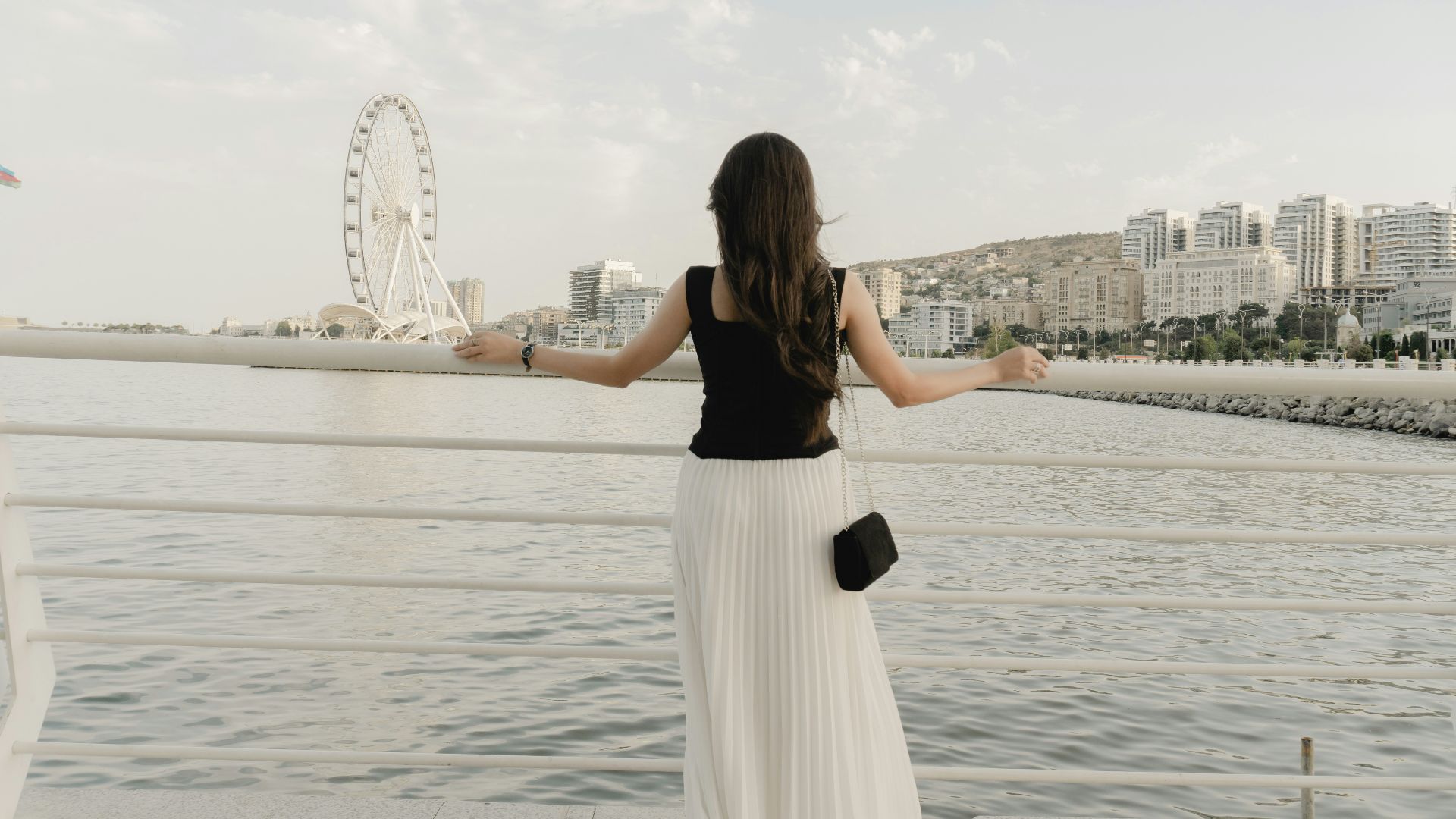 Woman looking at ferris wheel and city skyline