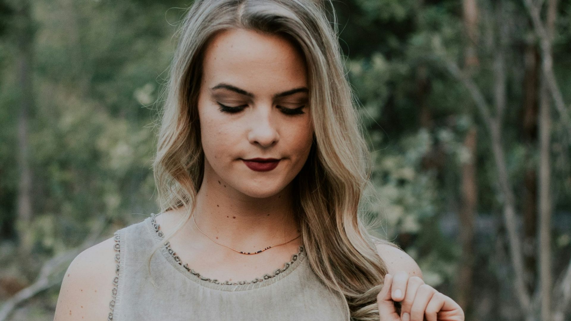 selective focus photography of woman holding her hair