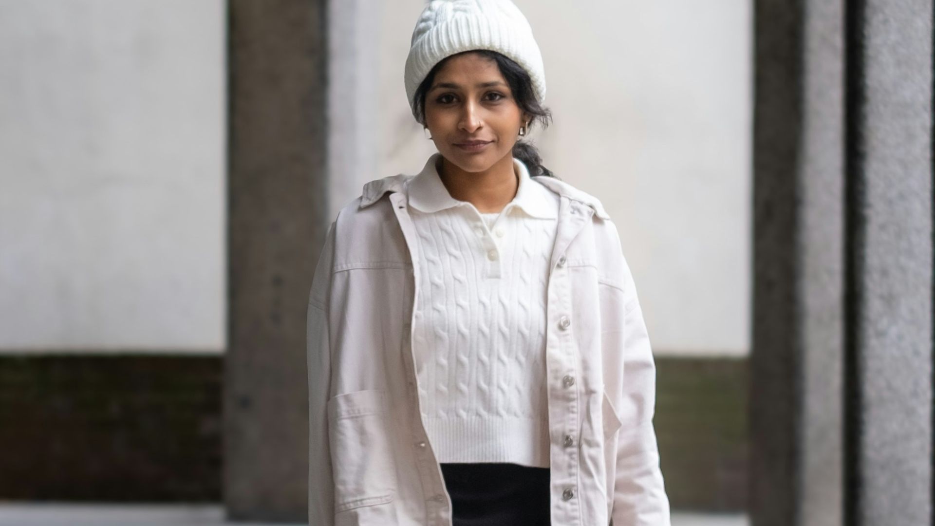 A woman walks down a stone pathway between columns
