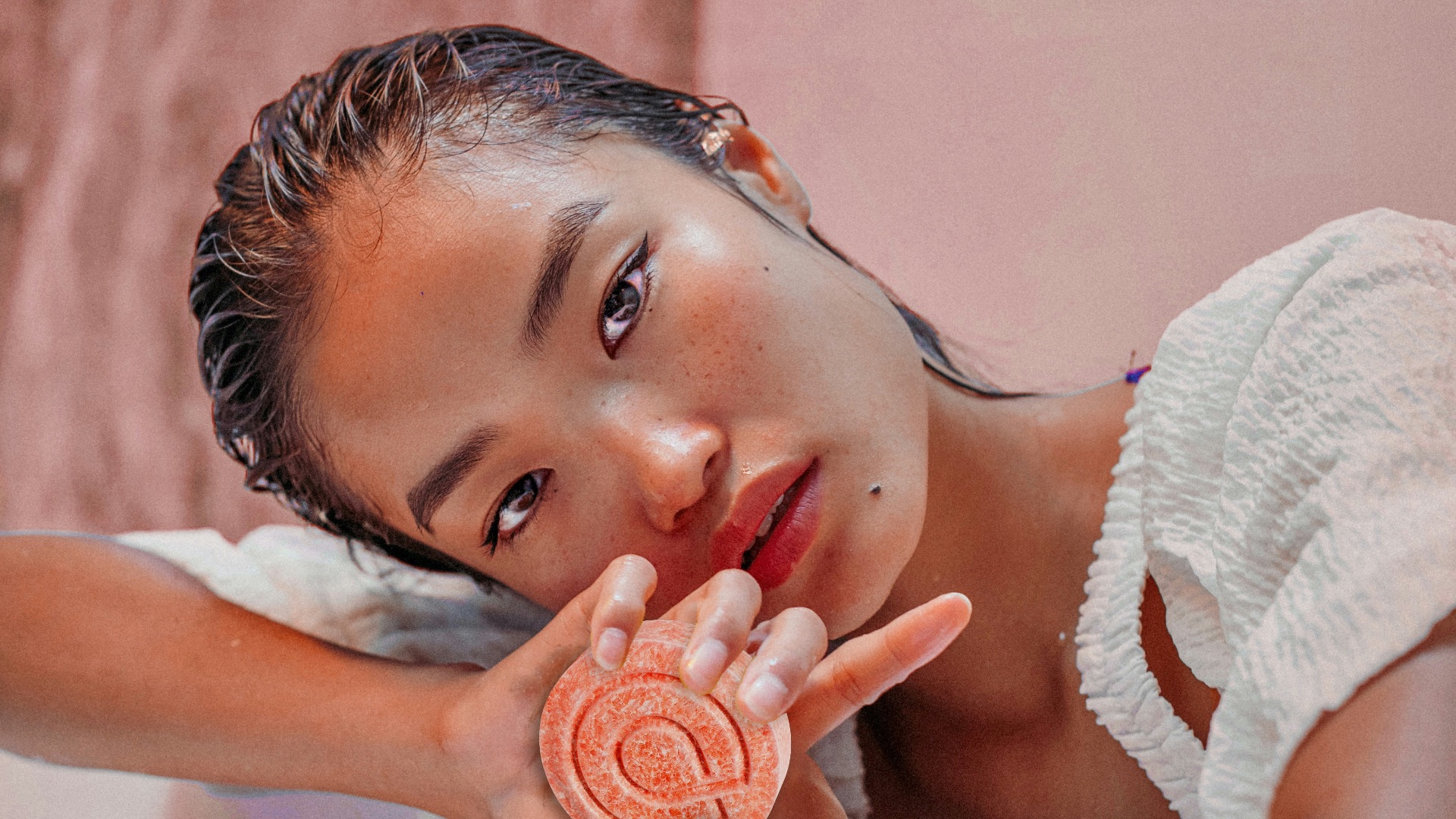 a woman laying on a counter holding a lollipop