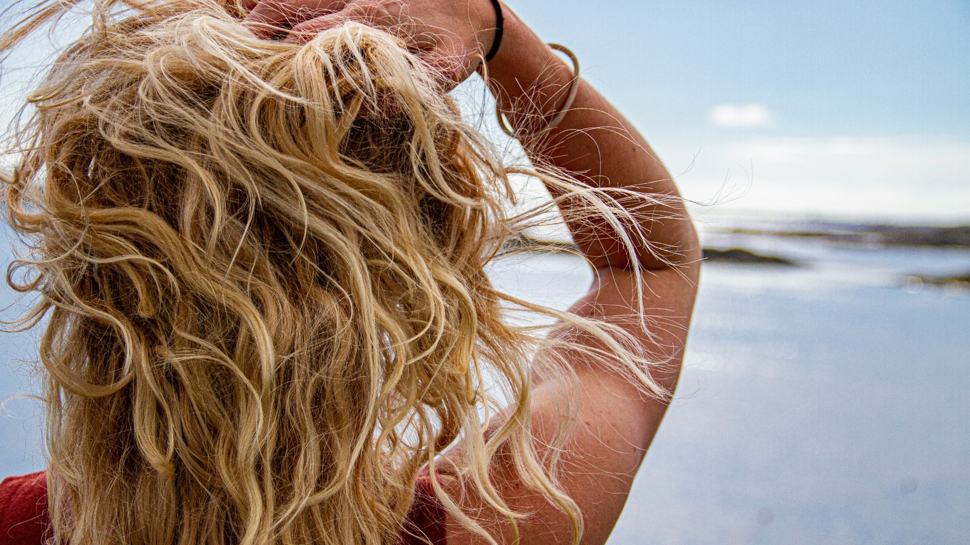 woman in black sunglasses covering her face with her hair