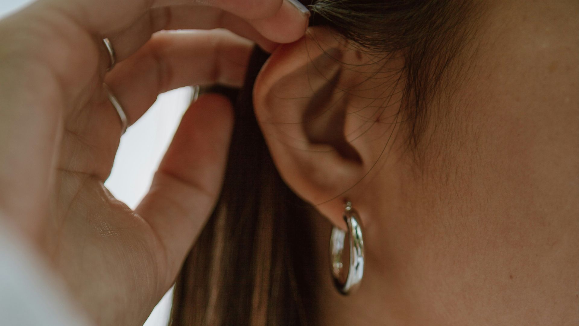 woman in white shirt wearing gold necklace