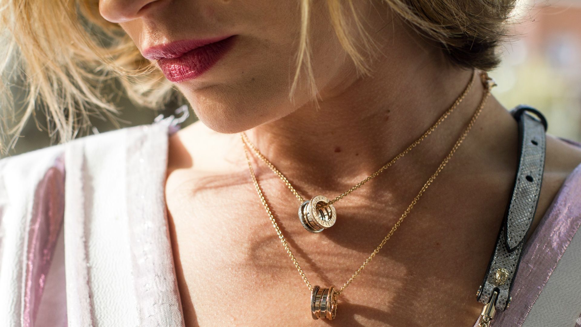 woman wearing gold-colored ring pendant necklaces