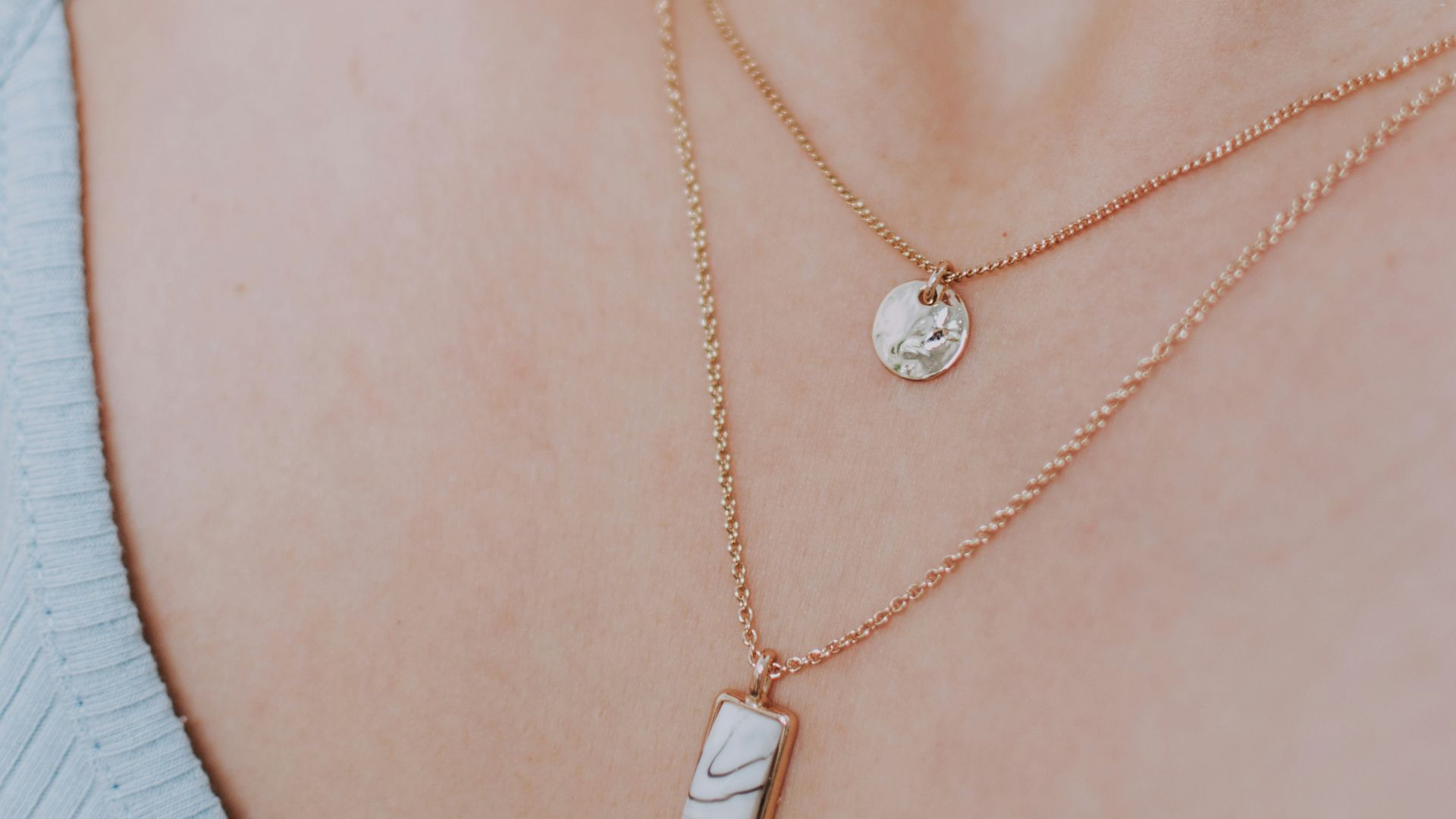 woman wearing gold necklace with silver pendant