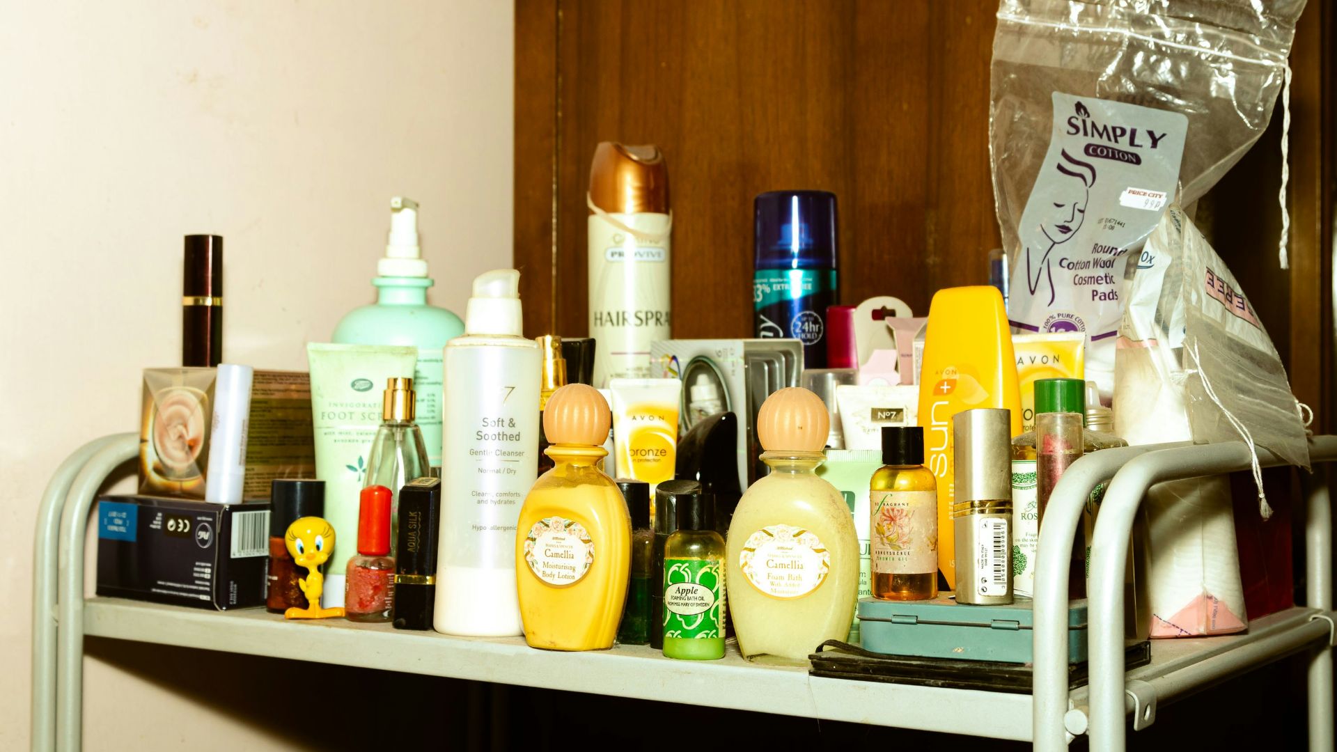 white and yellow plastic bottle on brown wooden shelf