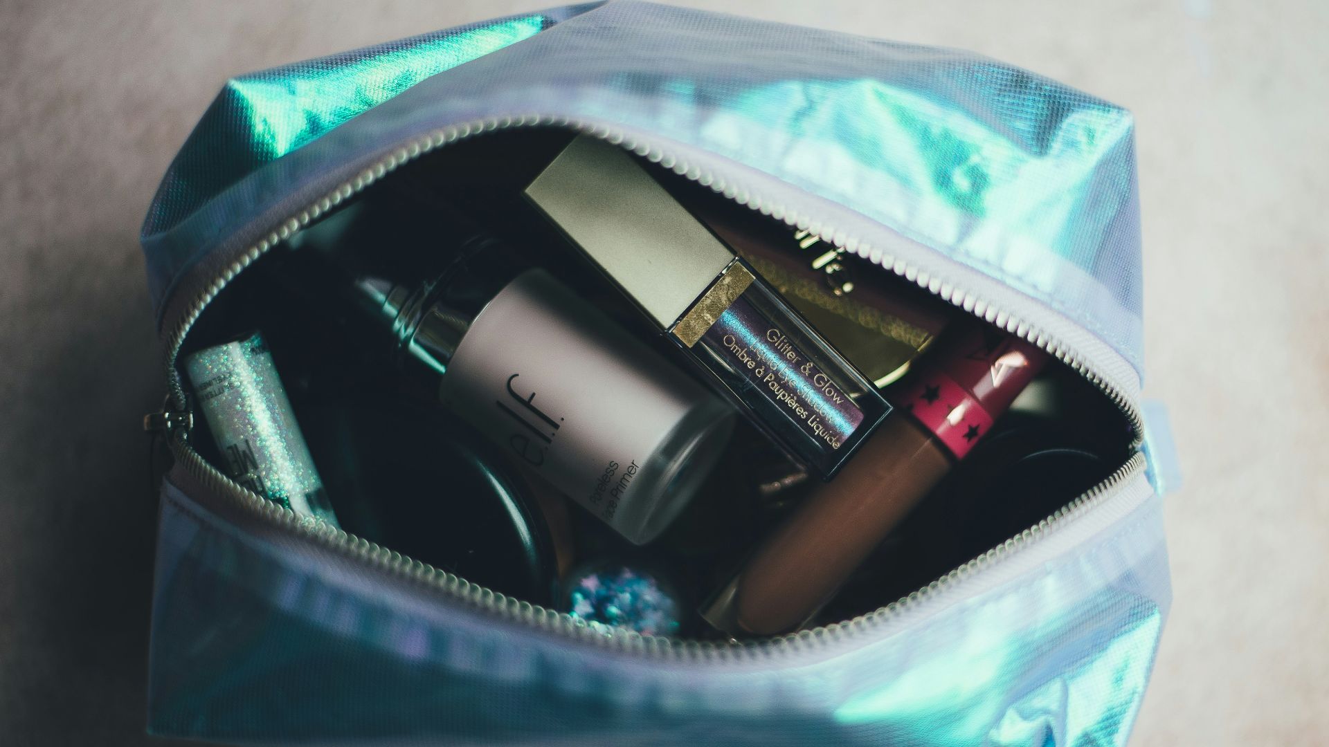 assorted cosmetic products on blue bag