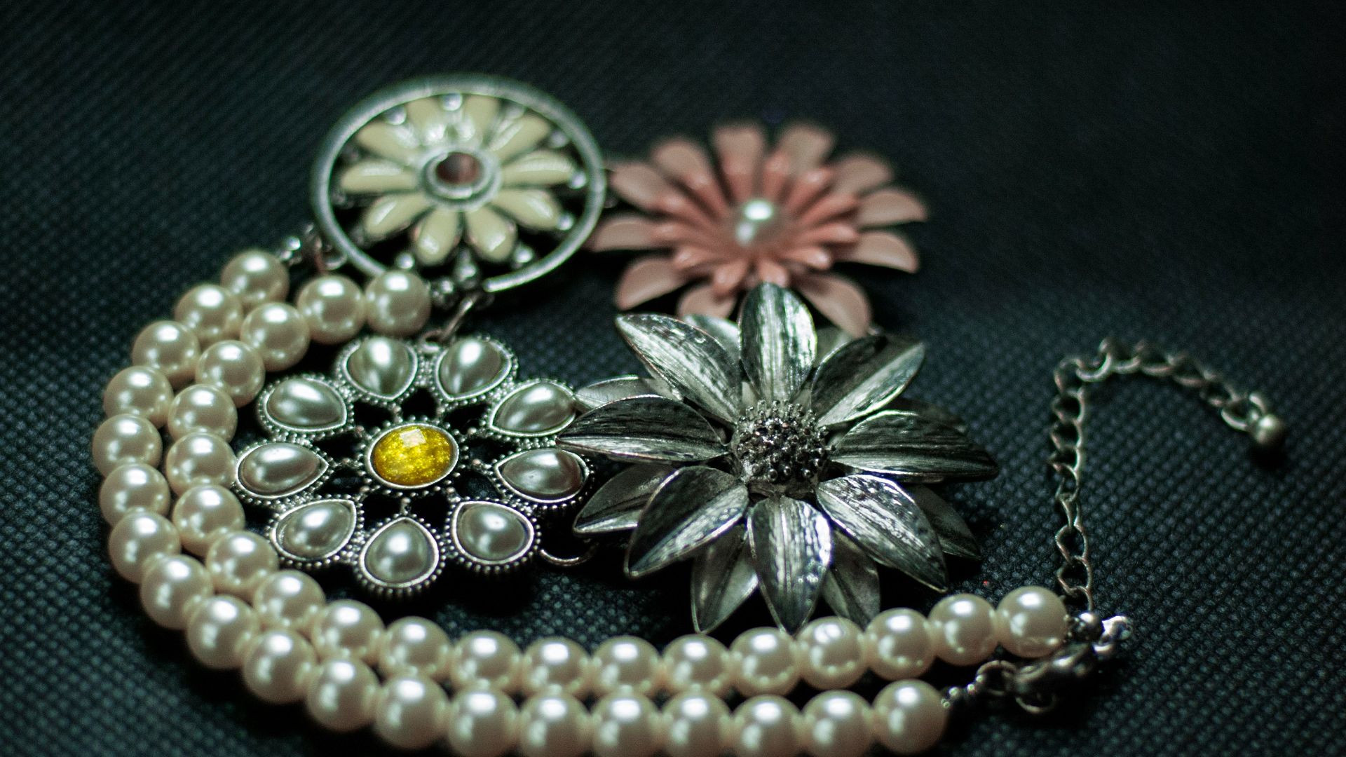 a close up of a necklace with flowers on it