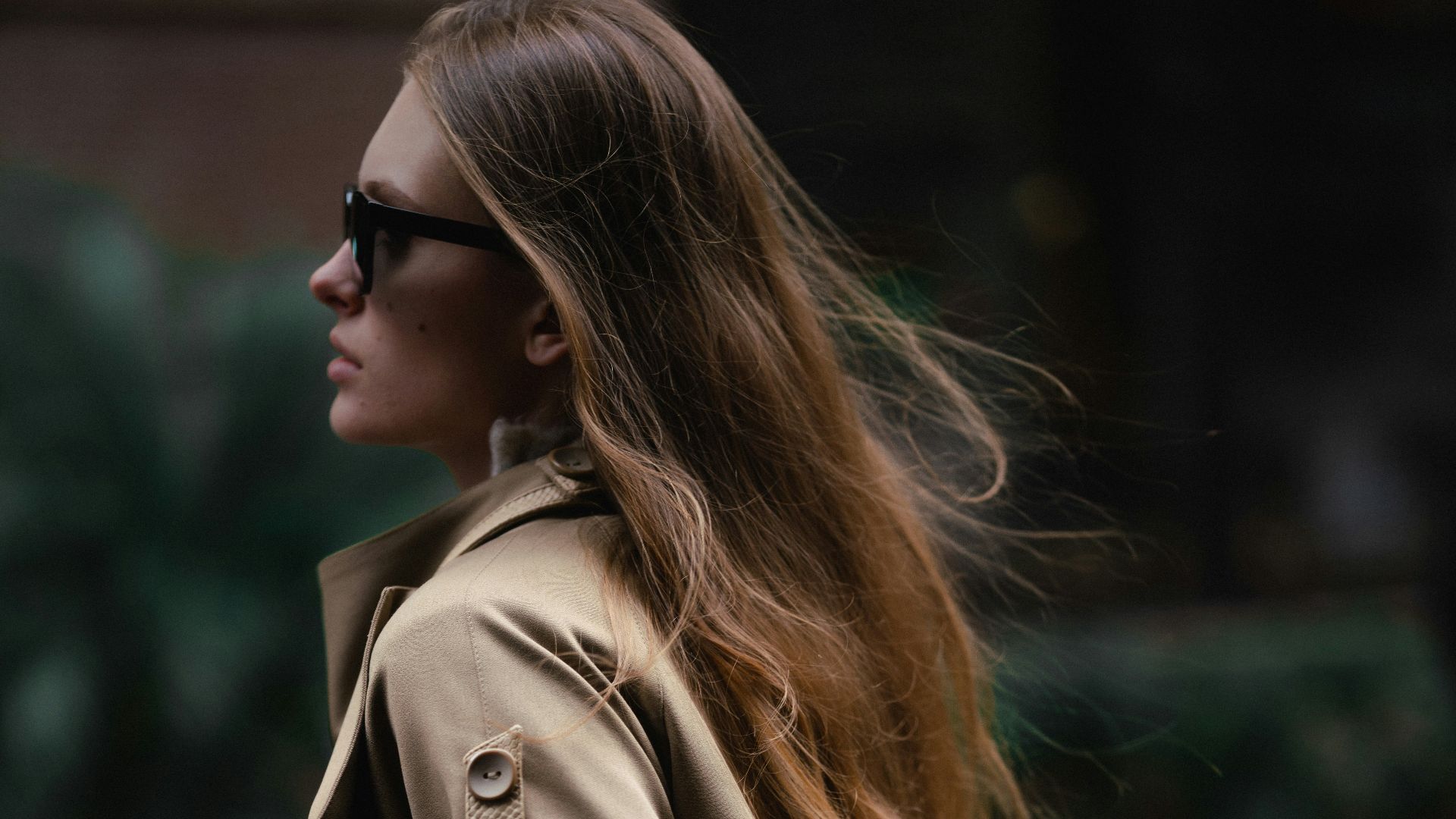 a woman walking down the street in a trench coat