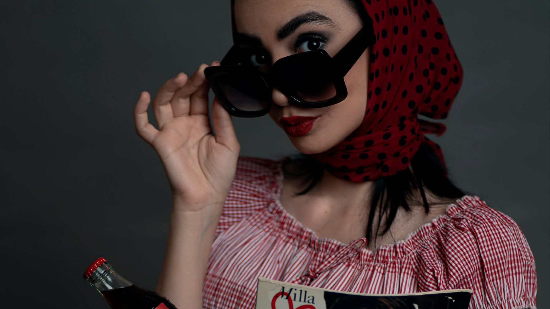 a woman in a red dress holding a bottle of wine