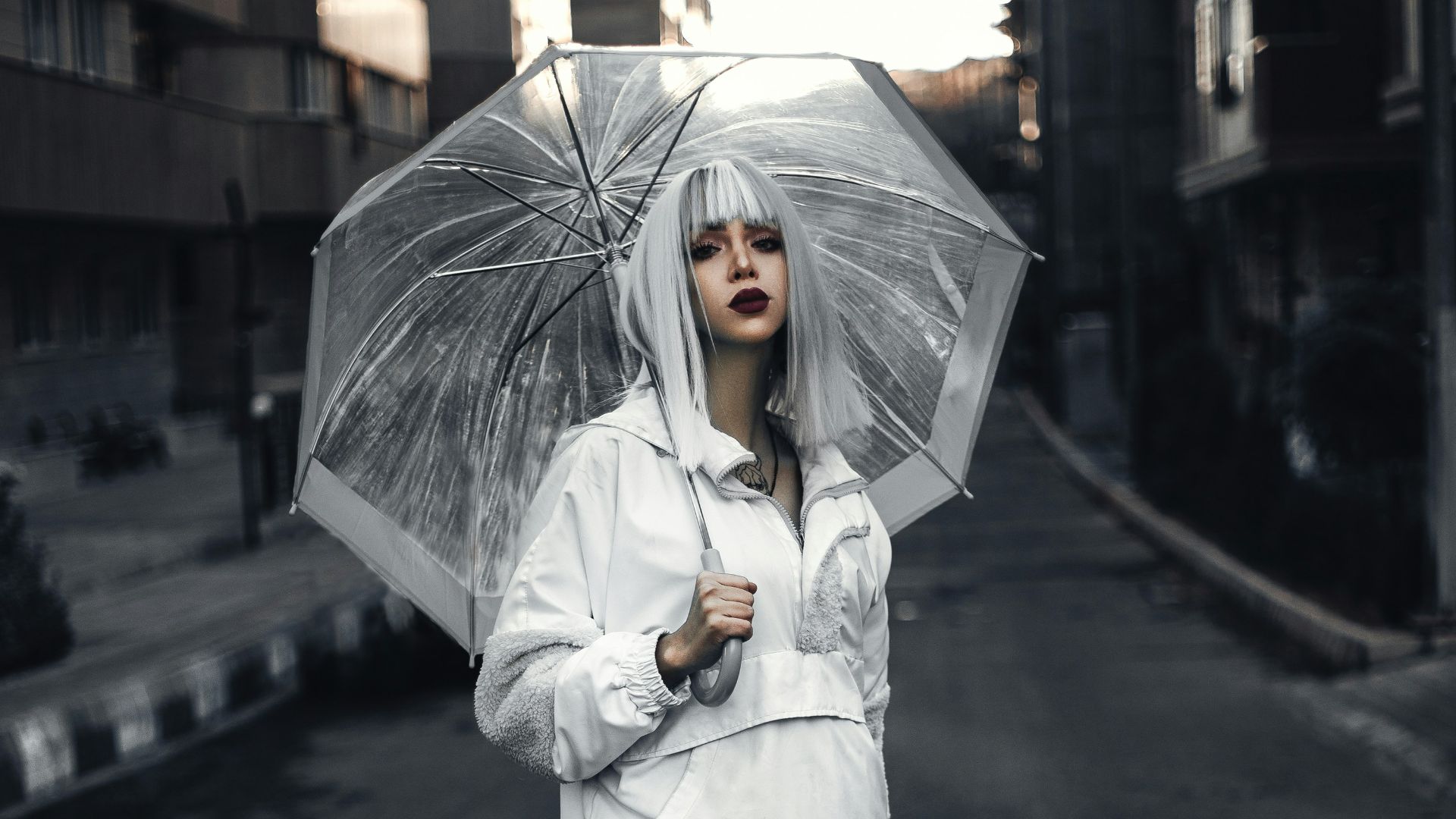 a woman walking down a street holding an umbrella