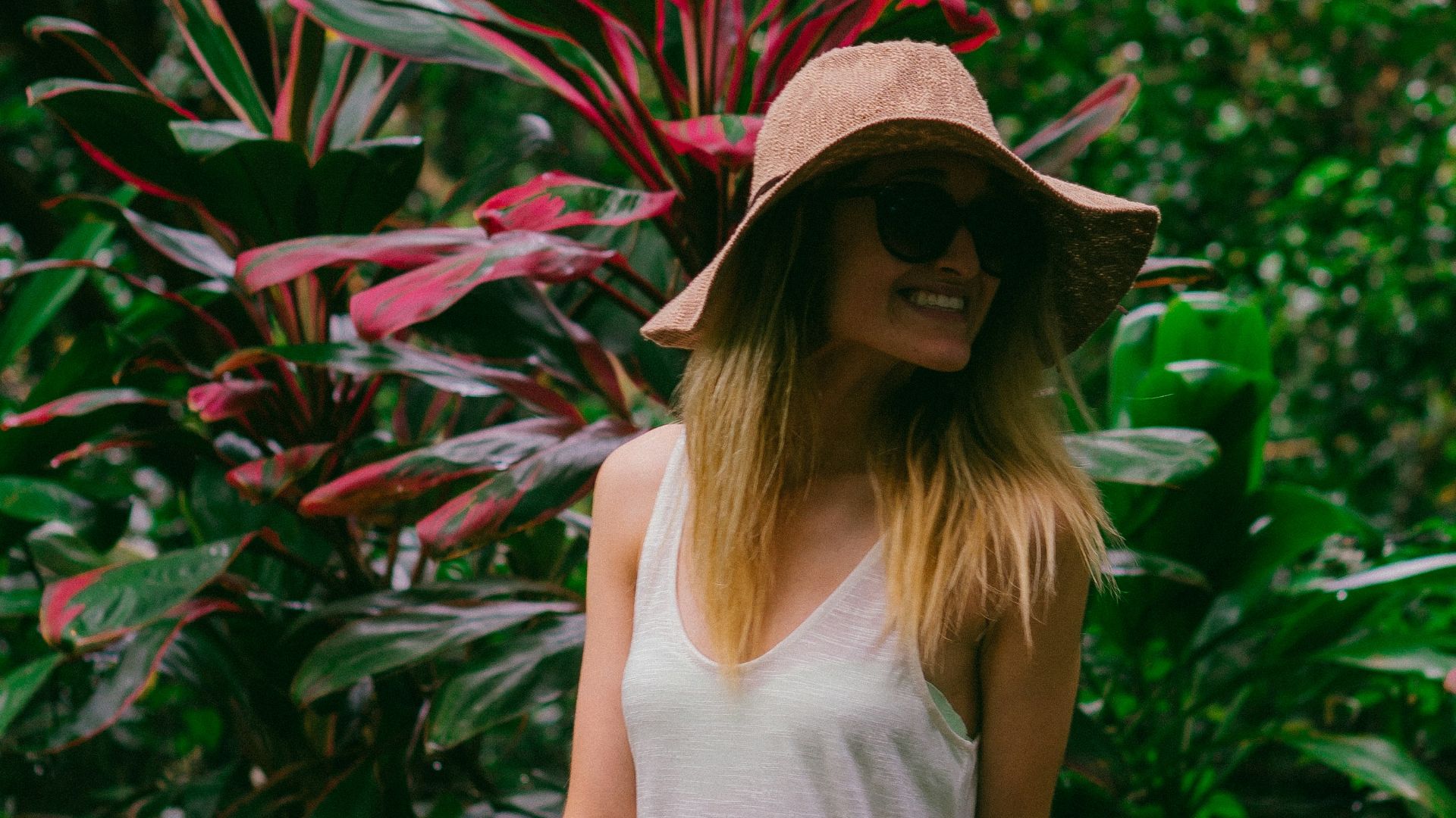 smiling woman in front of plant during daytime