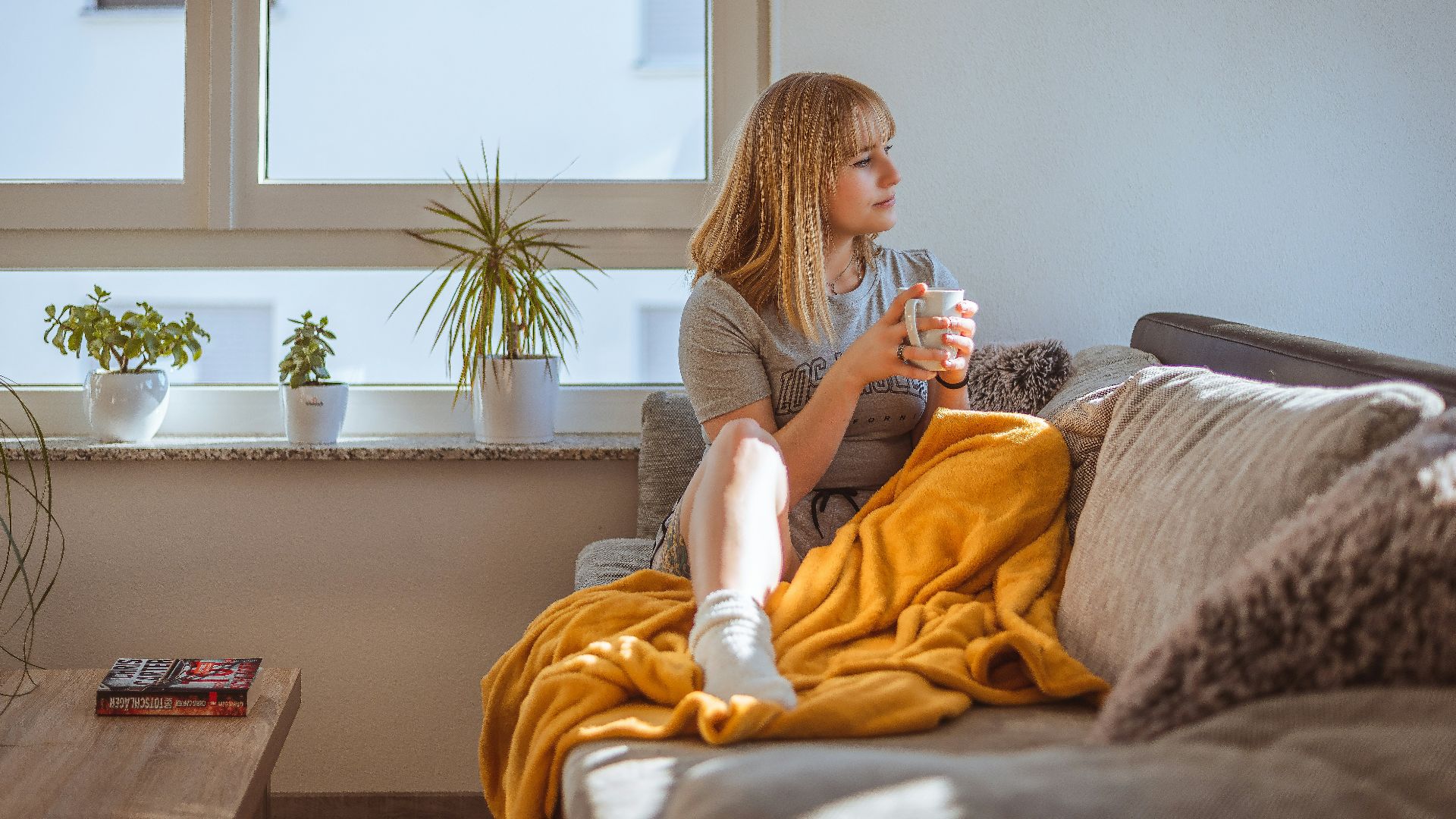 a woman sitting on a couch holding a glass of water