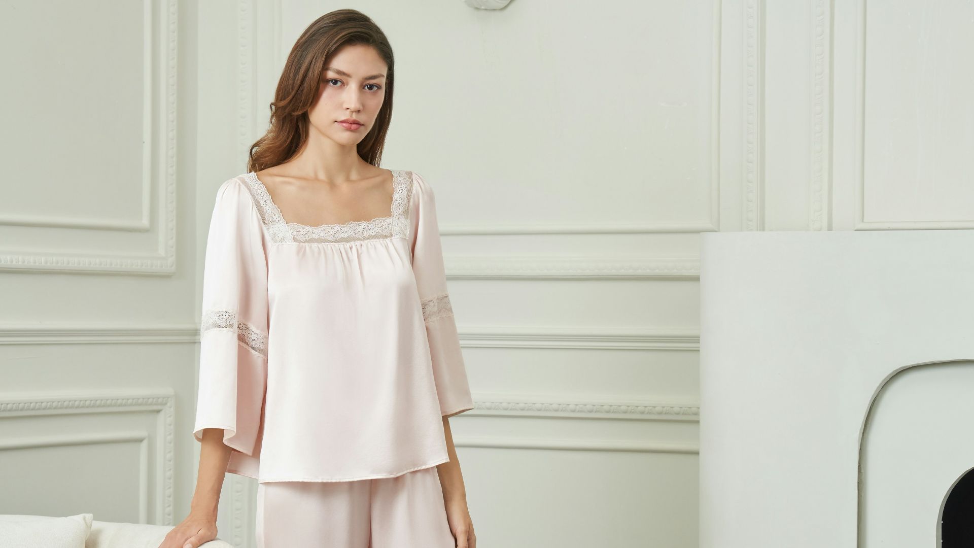 A woman in a pink silk pajama set