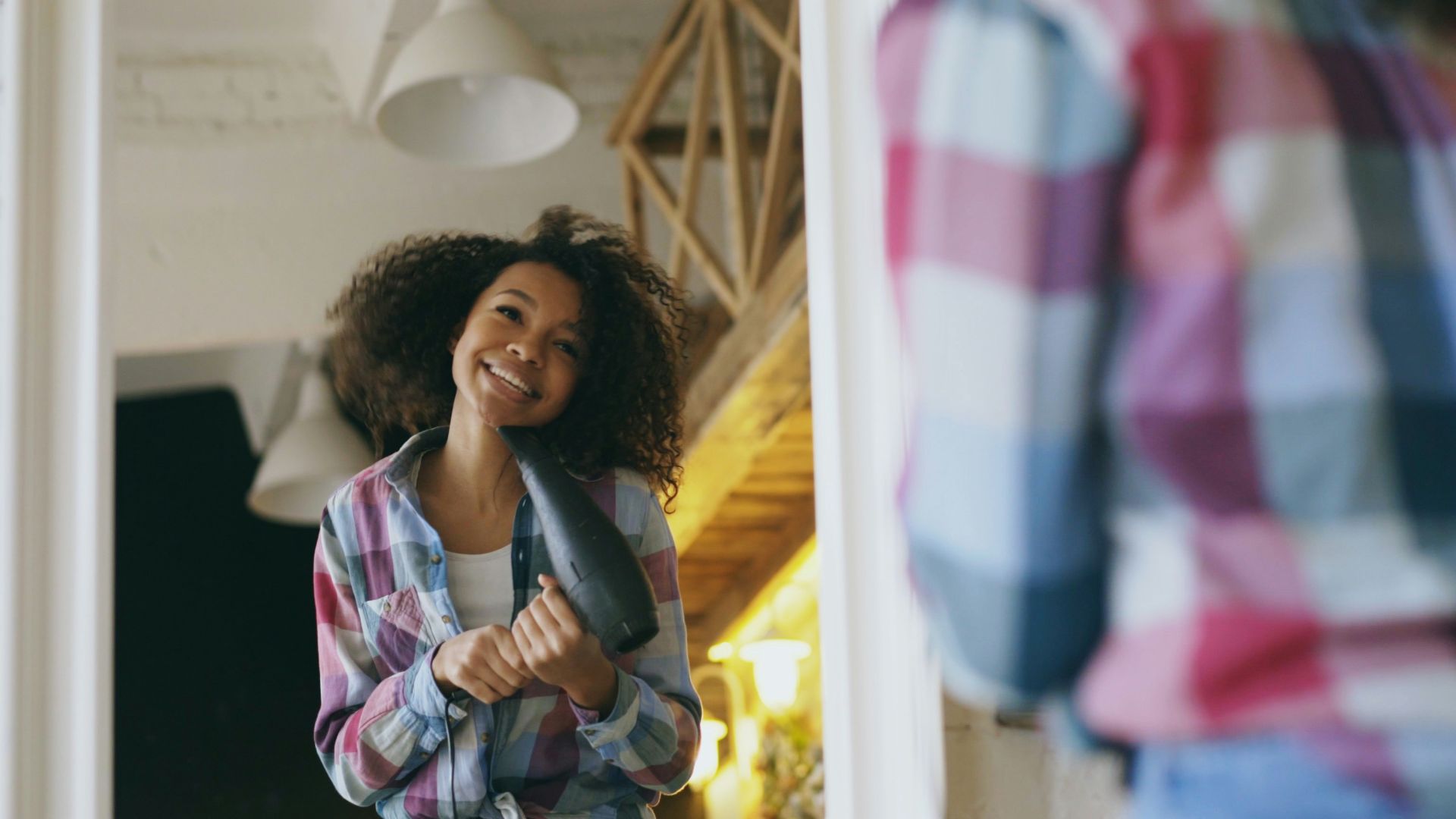 Young woman smiling while drying her hair