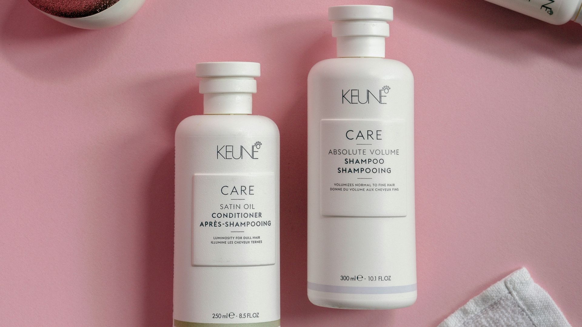 a bottle of keune care and a bottle of shampoo on a pink surface