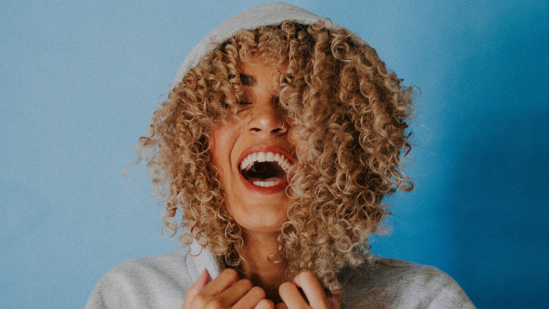 smiling woman wearing gray hoodie