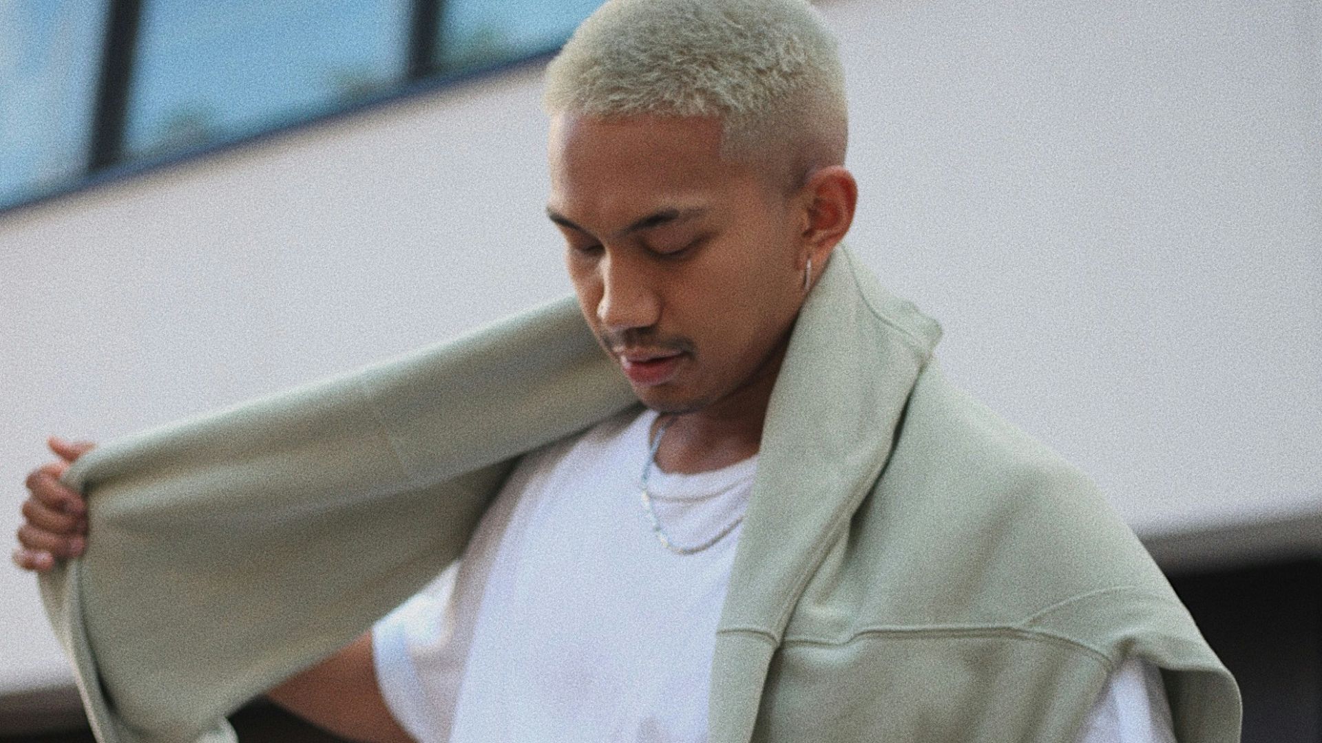 man in white polo shirt and blue denim jeans holding white textile