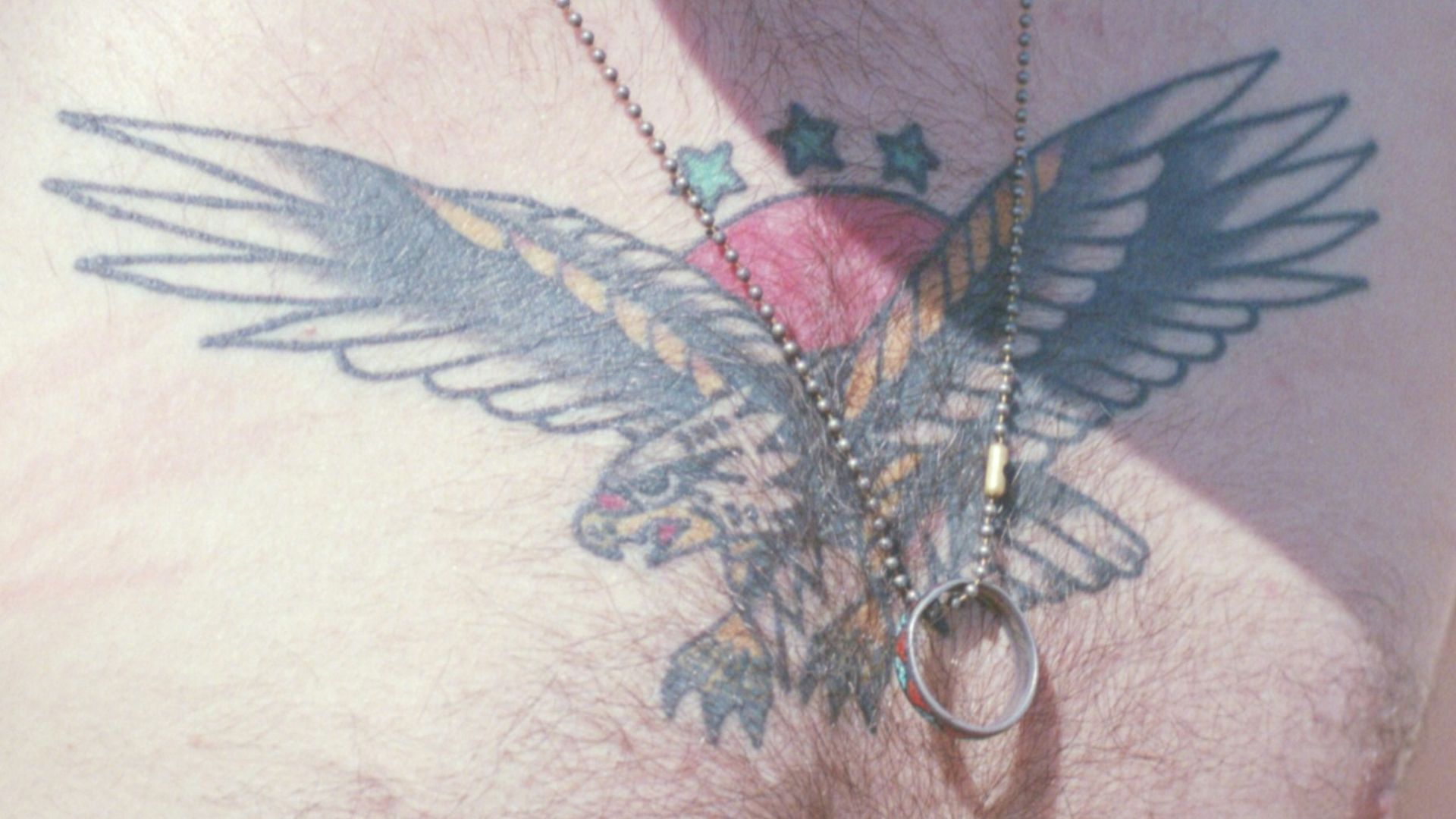 a man with a bird tattoo on his chest