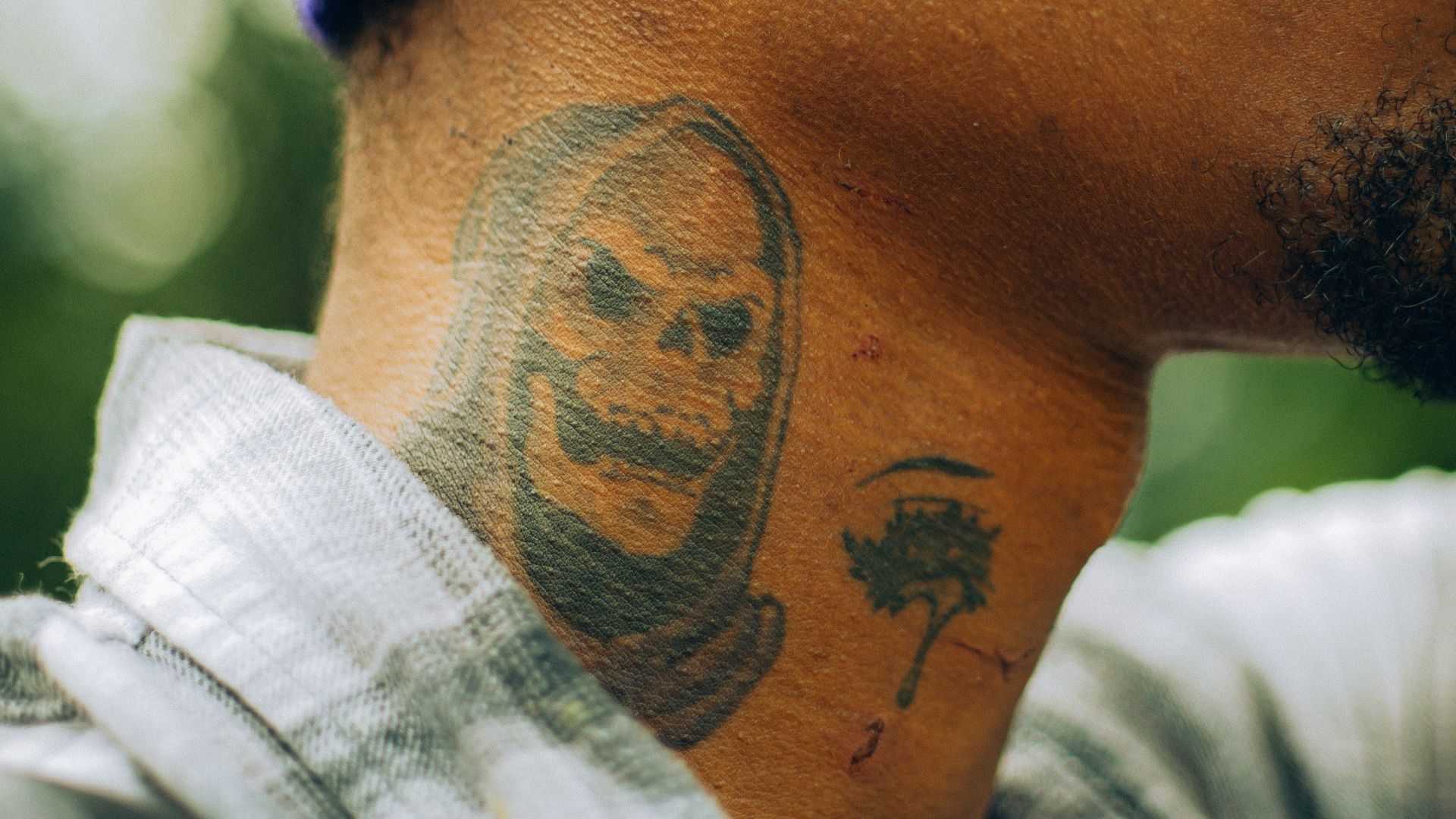 a man with a face tattoo on his neck