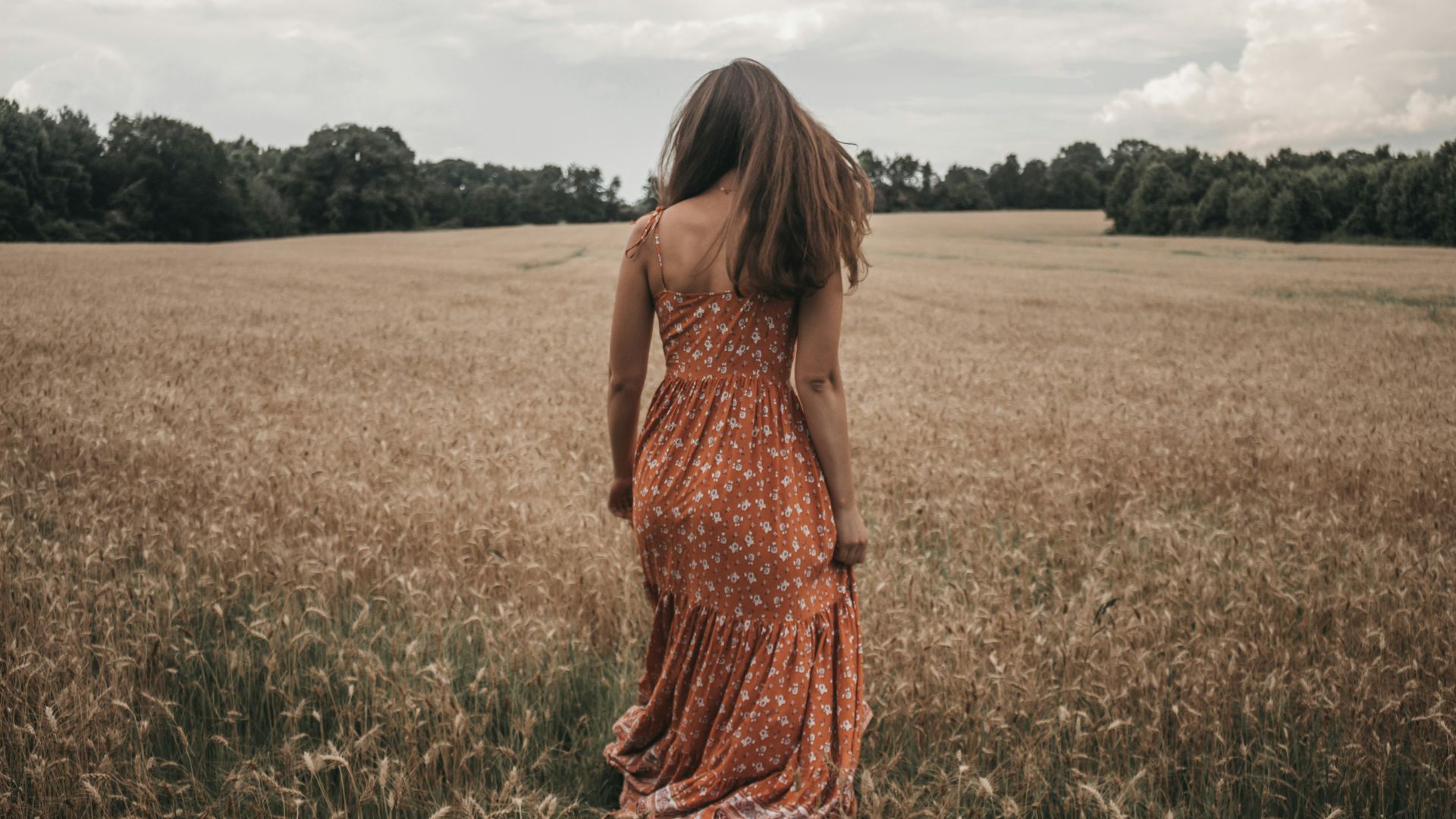 woman in orange dress on wheat field