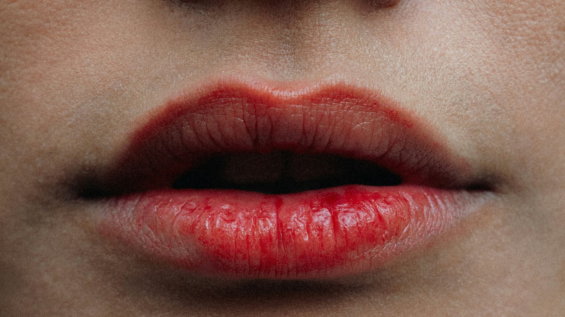 Close-up of a woman's red lips and nose