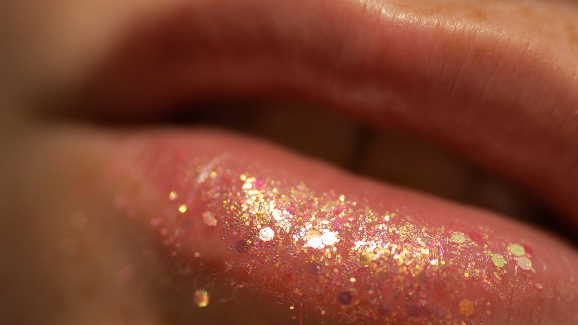 Close-up of a person's lips with glittery lip gloss.