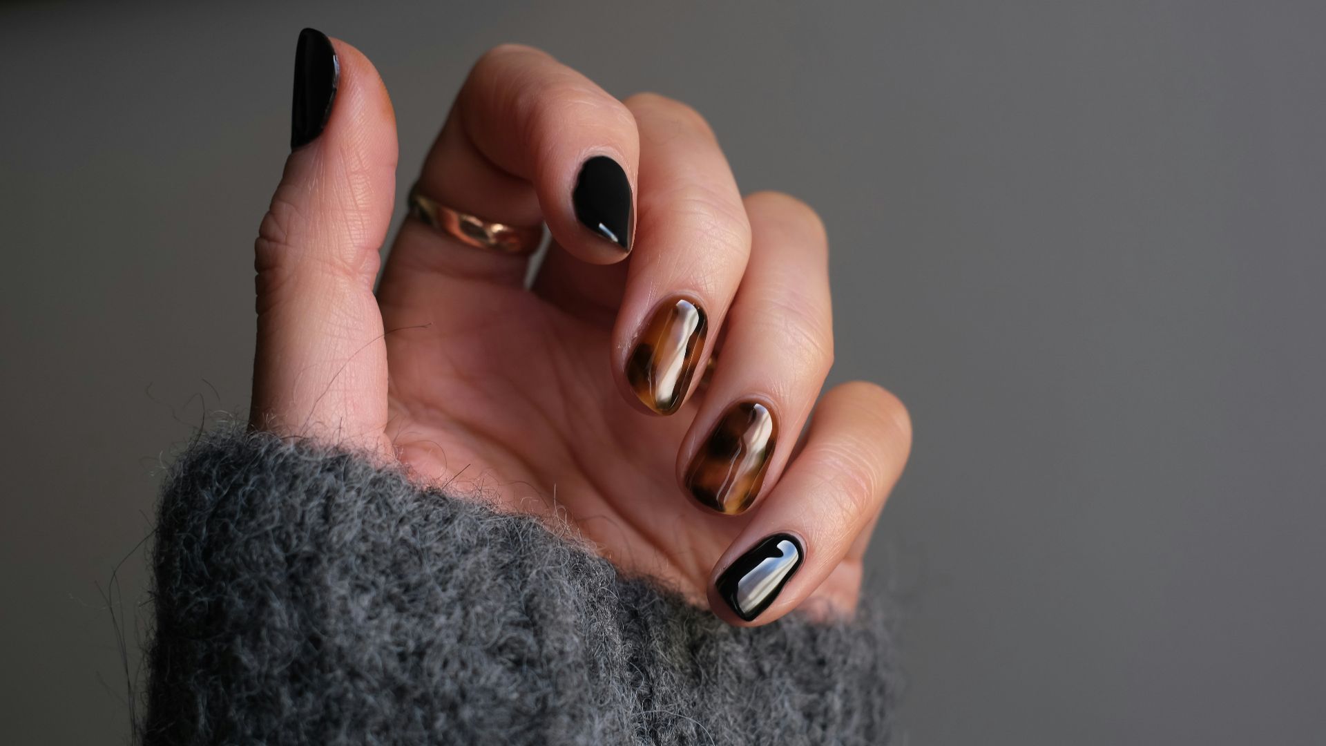 person wearing silver ring with black manicure