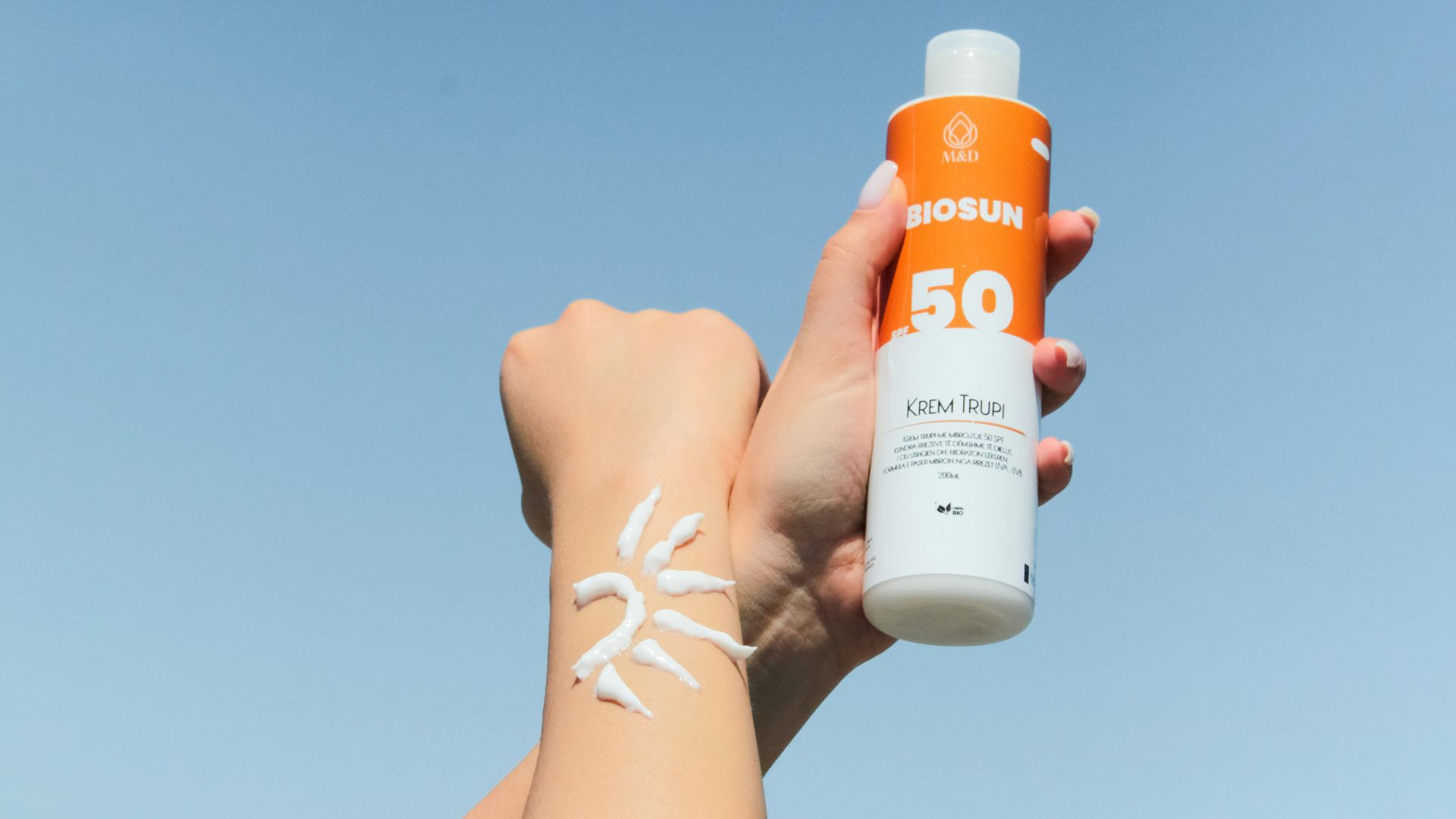 a person holding a bottle of sunscreen in their hand
