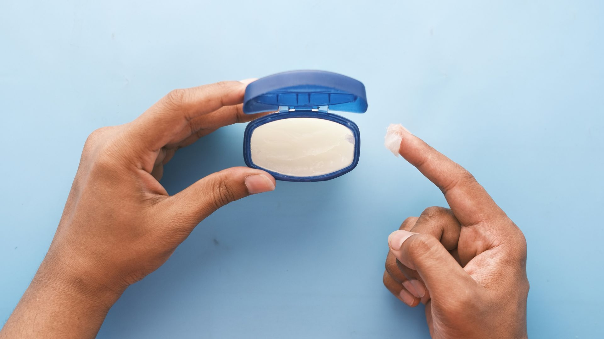 person holding blue round container