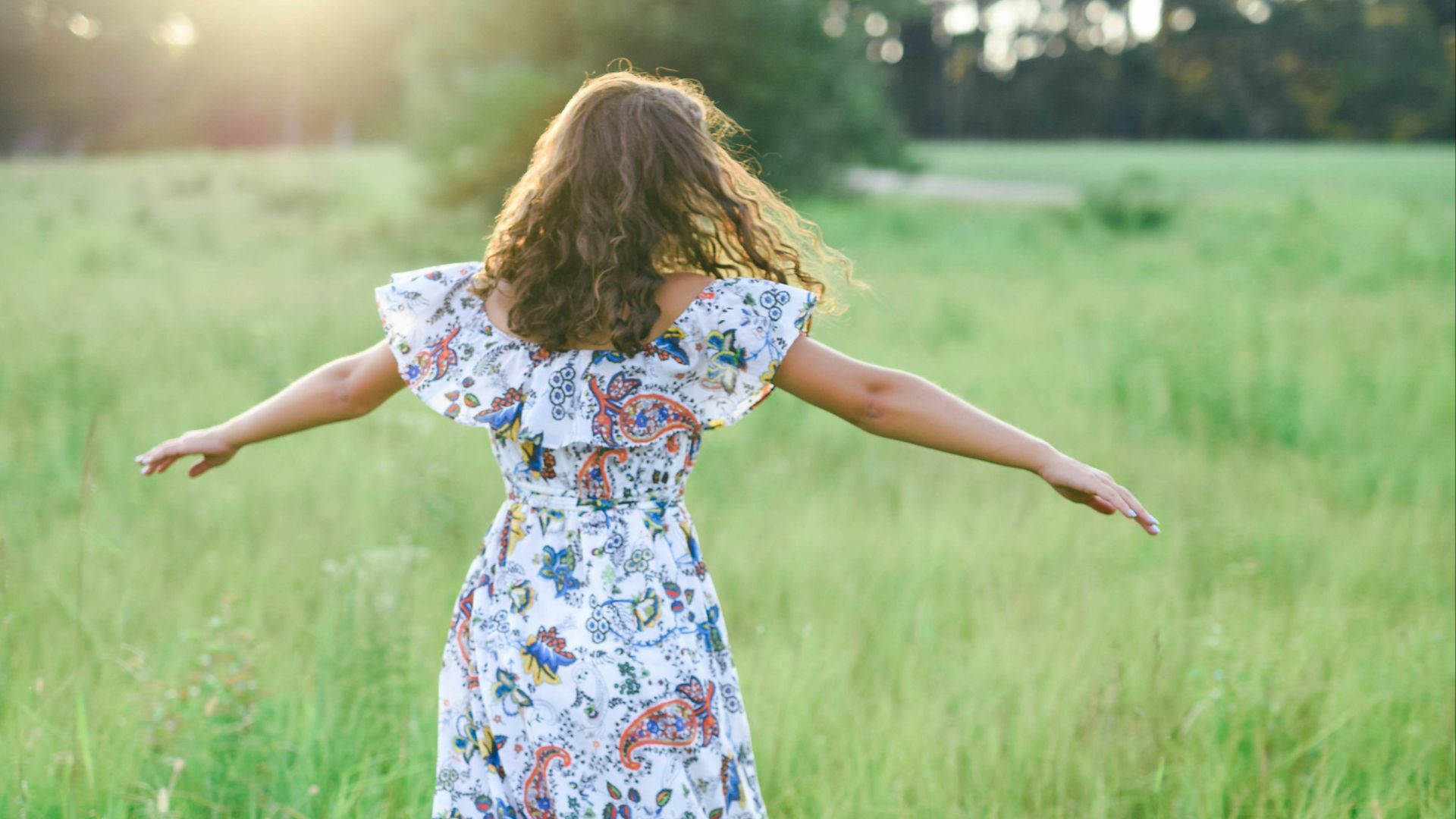 shallow focus photography of woman in white, blue, and green floral dress