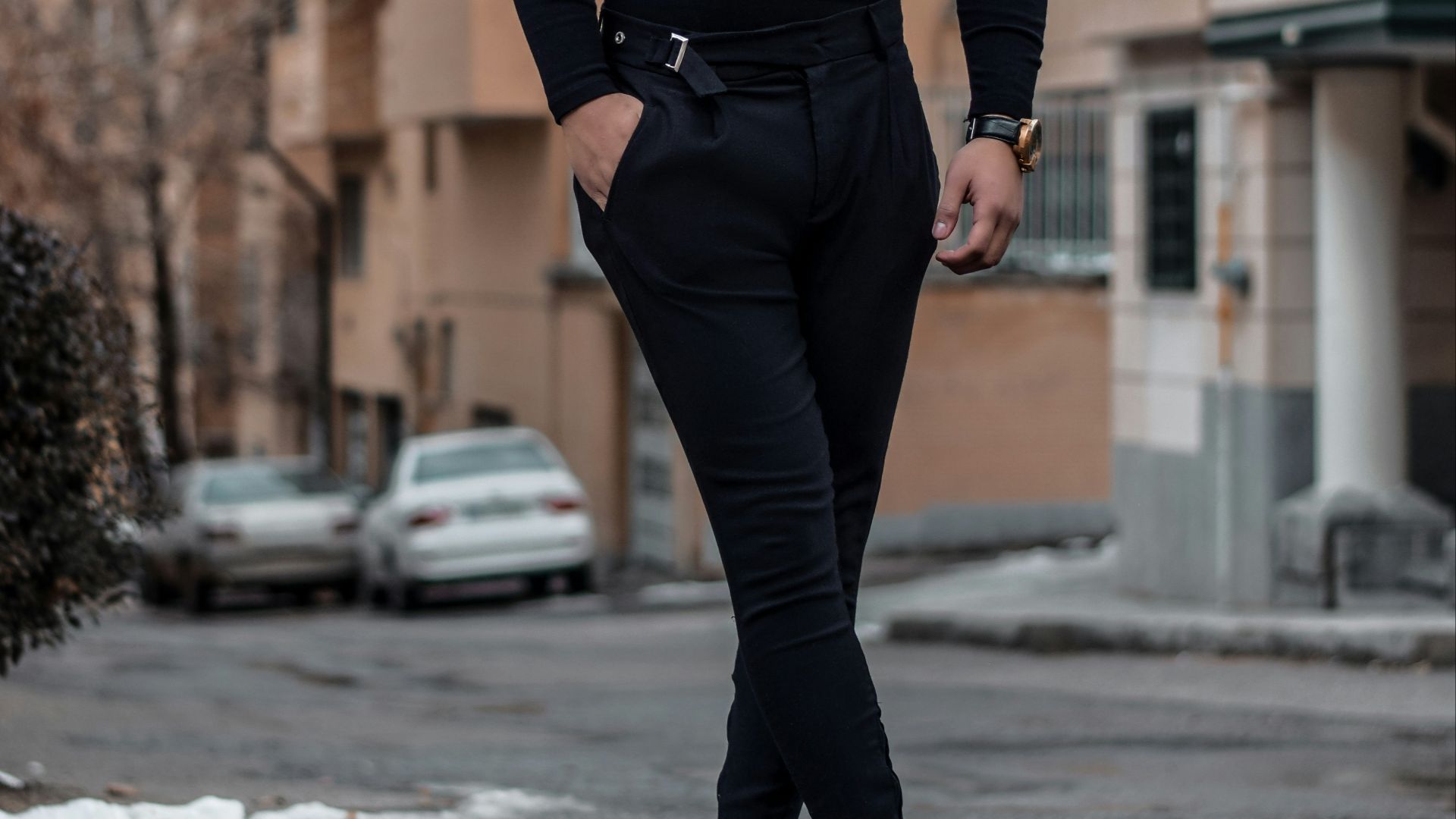 man in black dress shirt, necktie, and pants standing on street