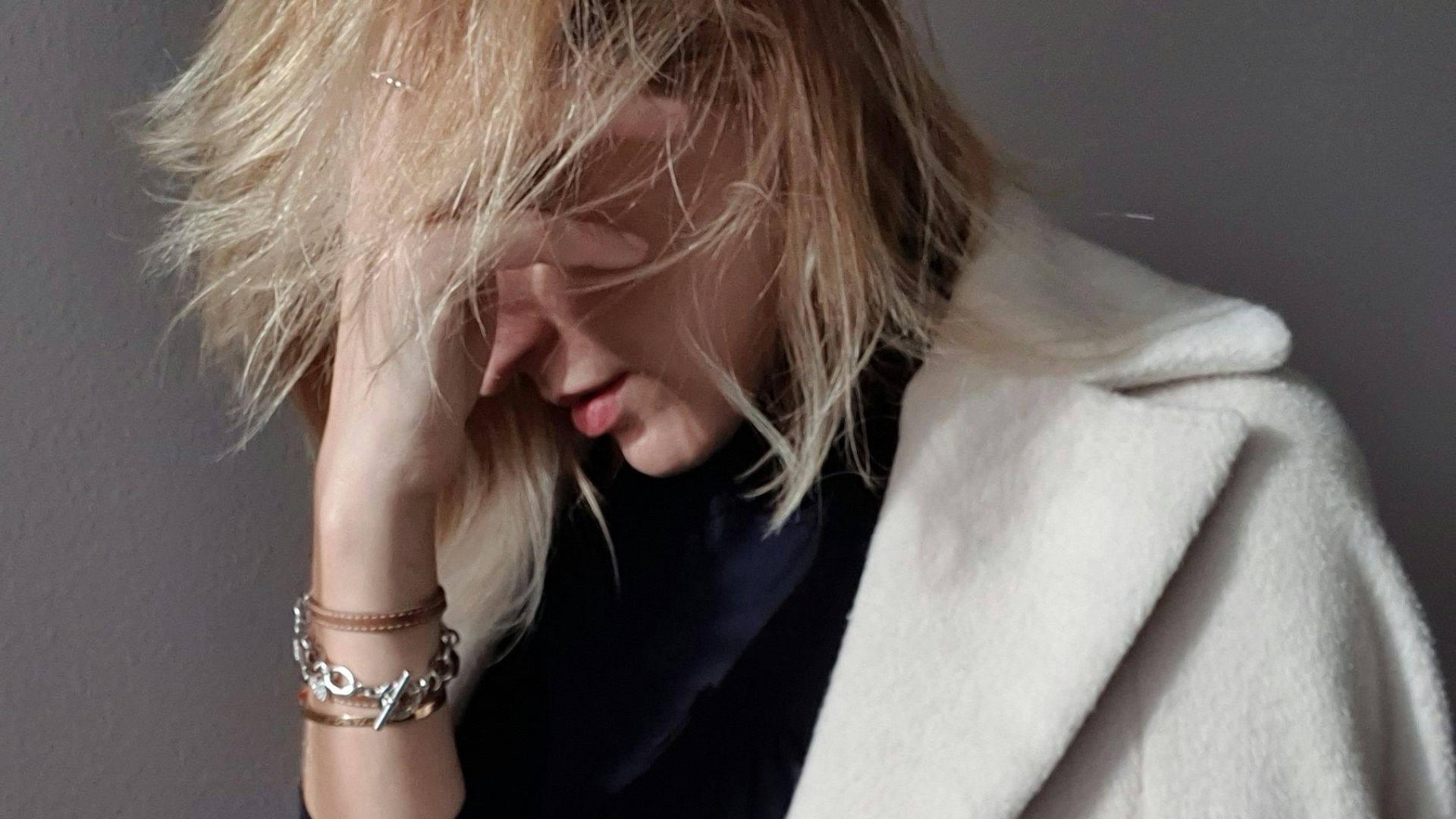 a woman with blonde hair wearing a white coat