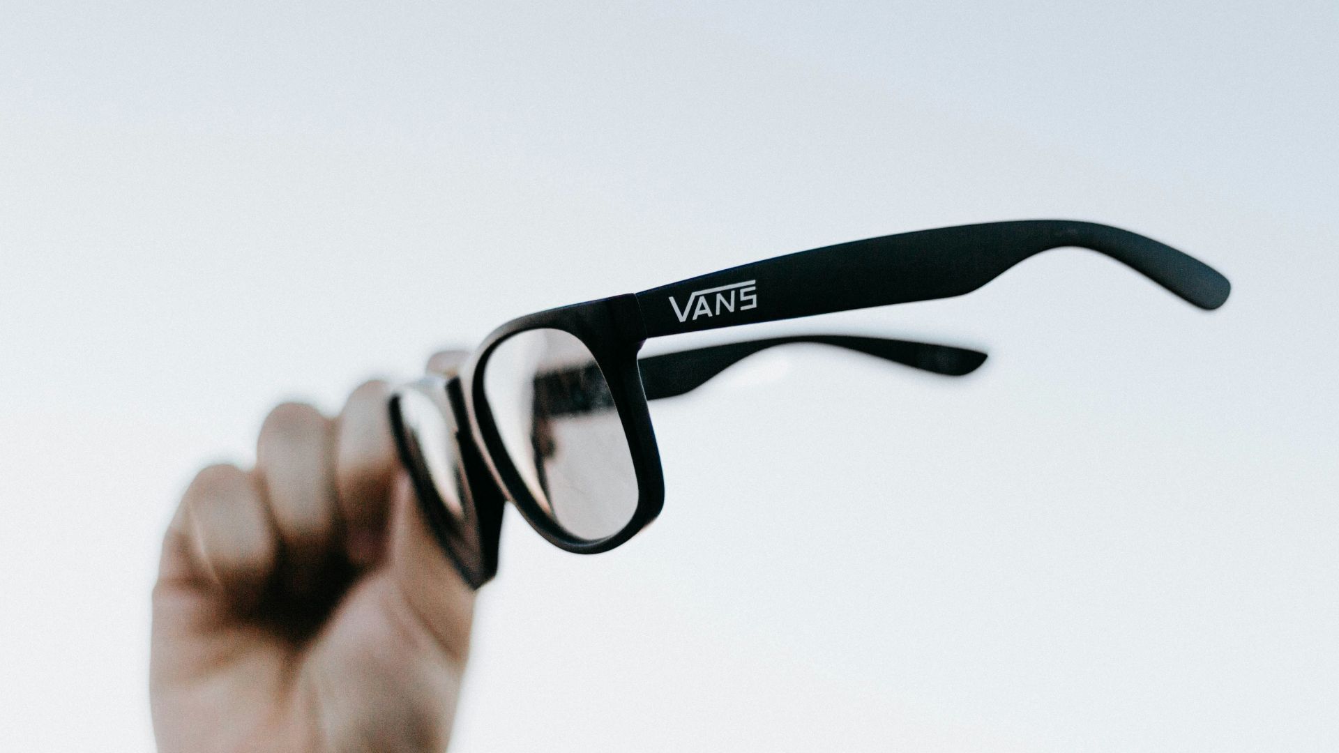 a hand holding up a pair of glasses