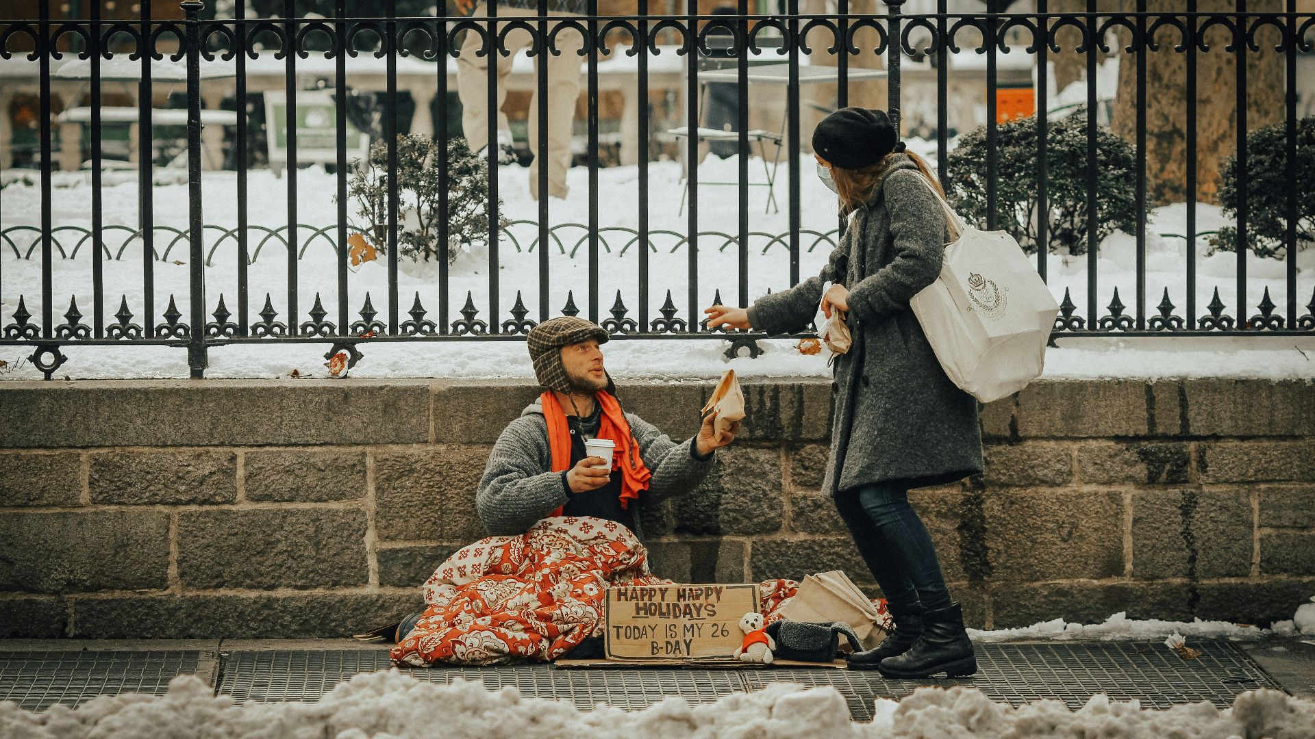 man in black jacket and black pants sitting on white snow covered ground during daytime