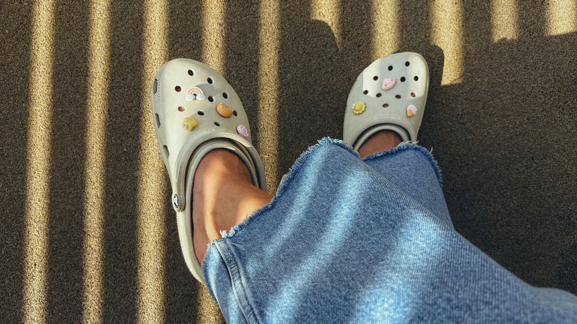 White clogs with smiley faces on denim legs