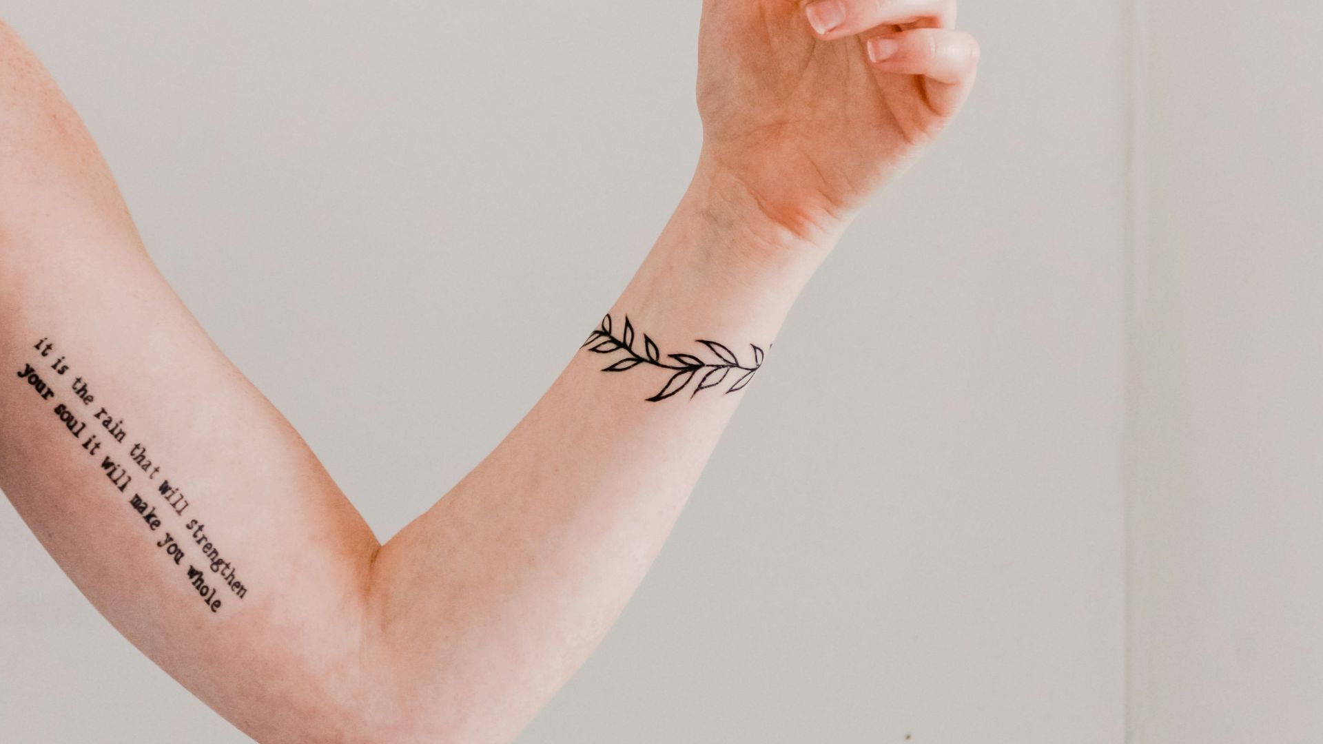 person showing arm and wrist tattoo