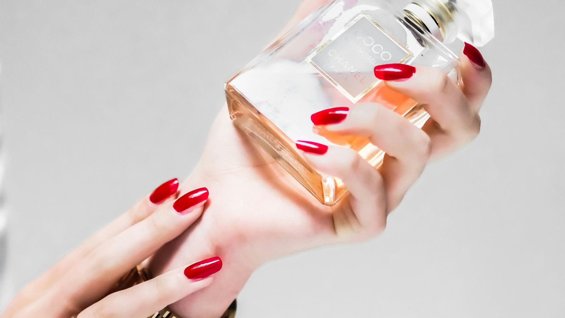 person holding clear glass bottle