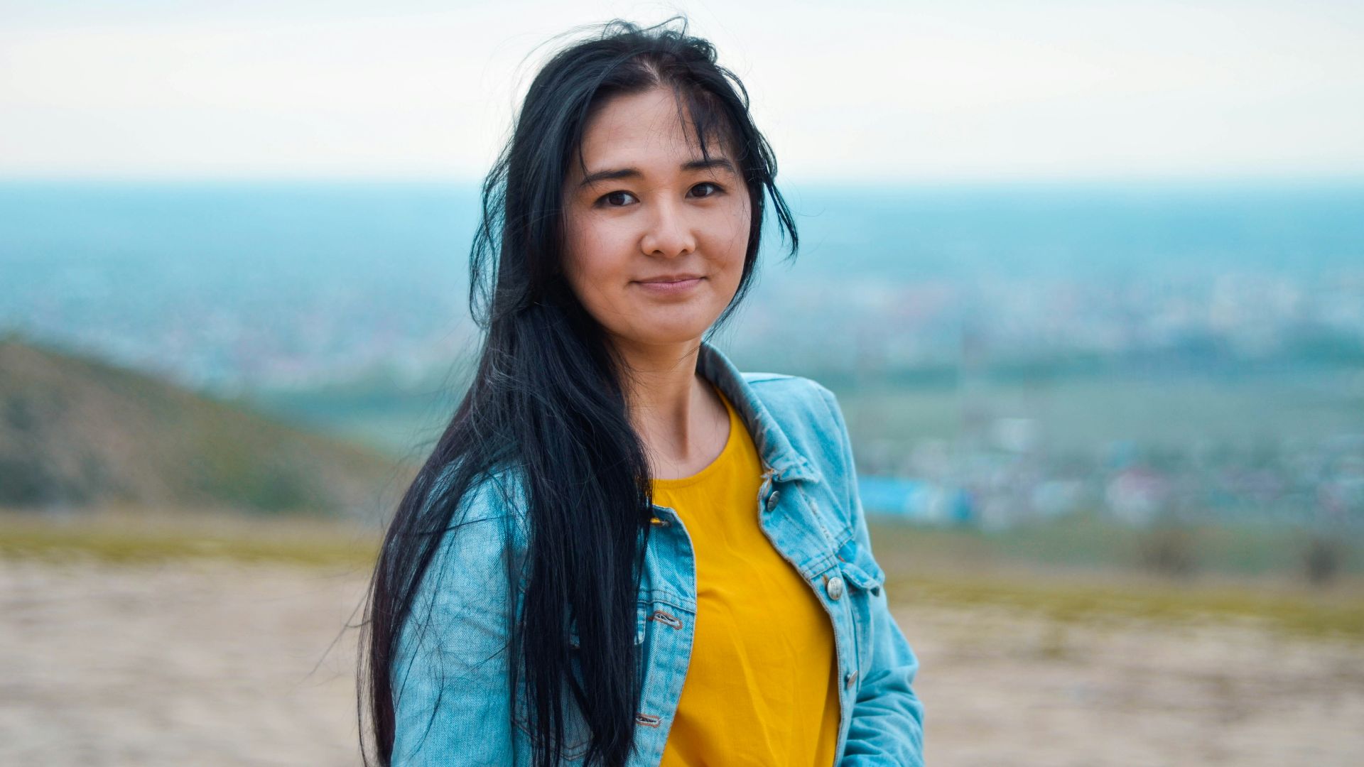 woman wearing blue denim jacket with yellow shirt