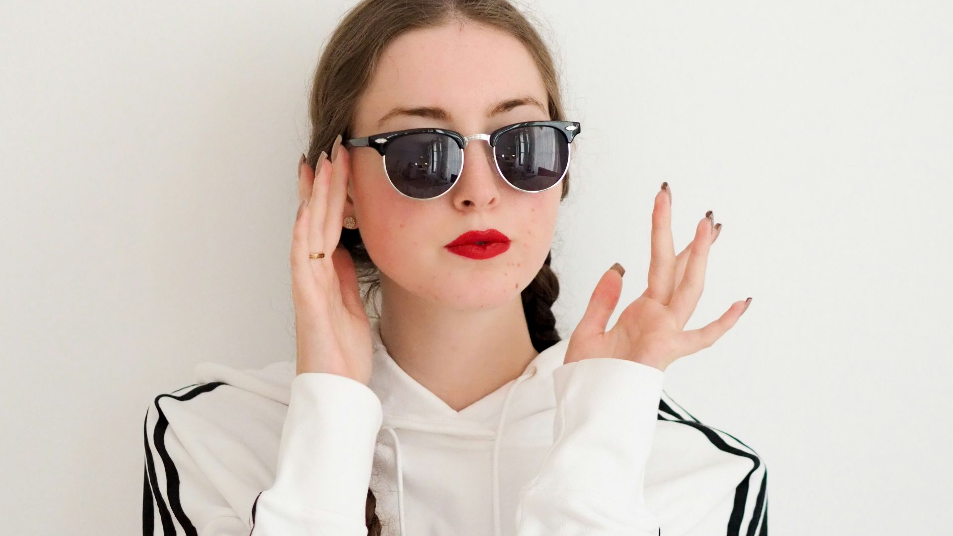 woman in white dress shirt wearing black framed sunglasses