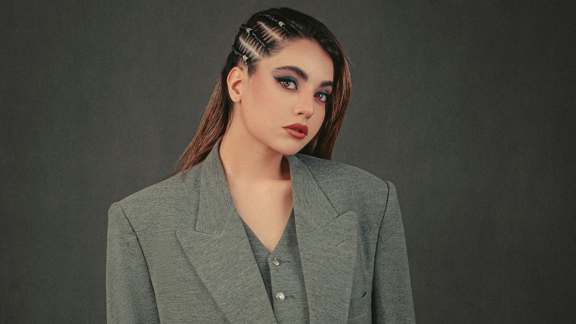 a woman in a gray jacket and black pants