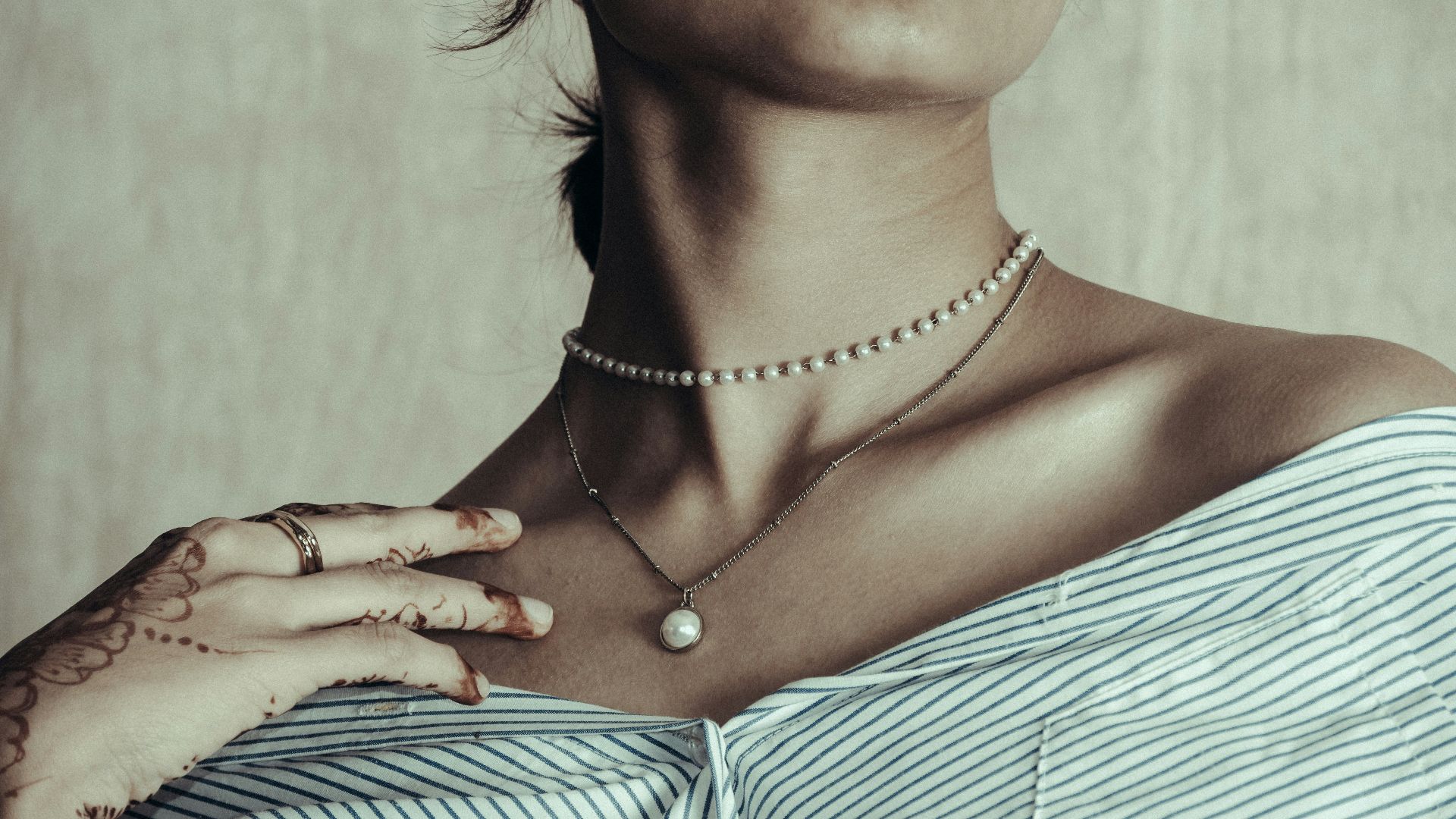 Woman wearing pearl necklaces and striped shirt