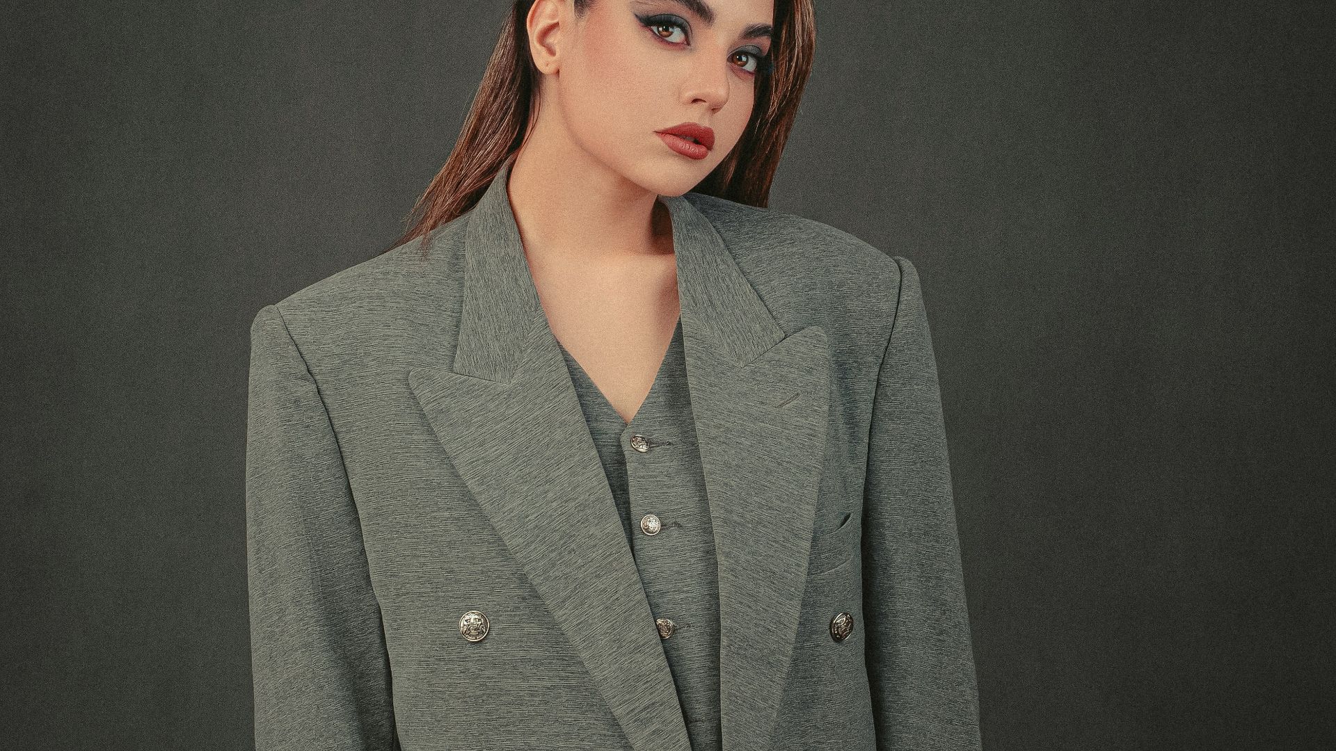 a woman in a gray jacket and black pants