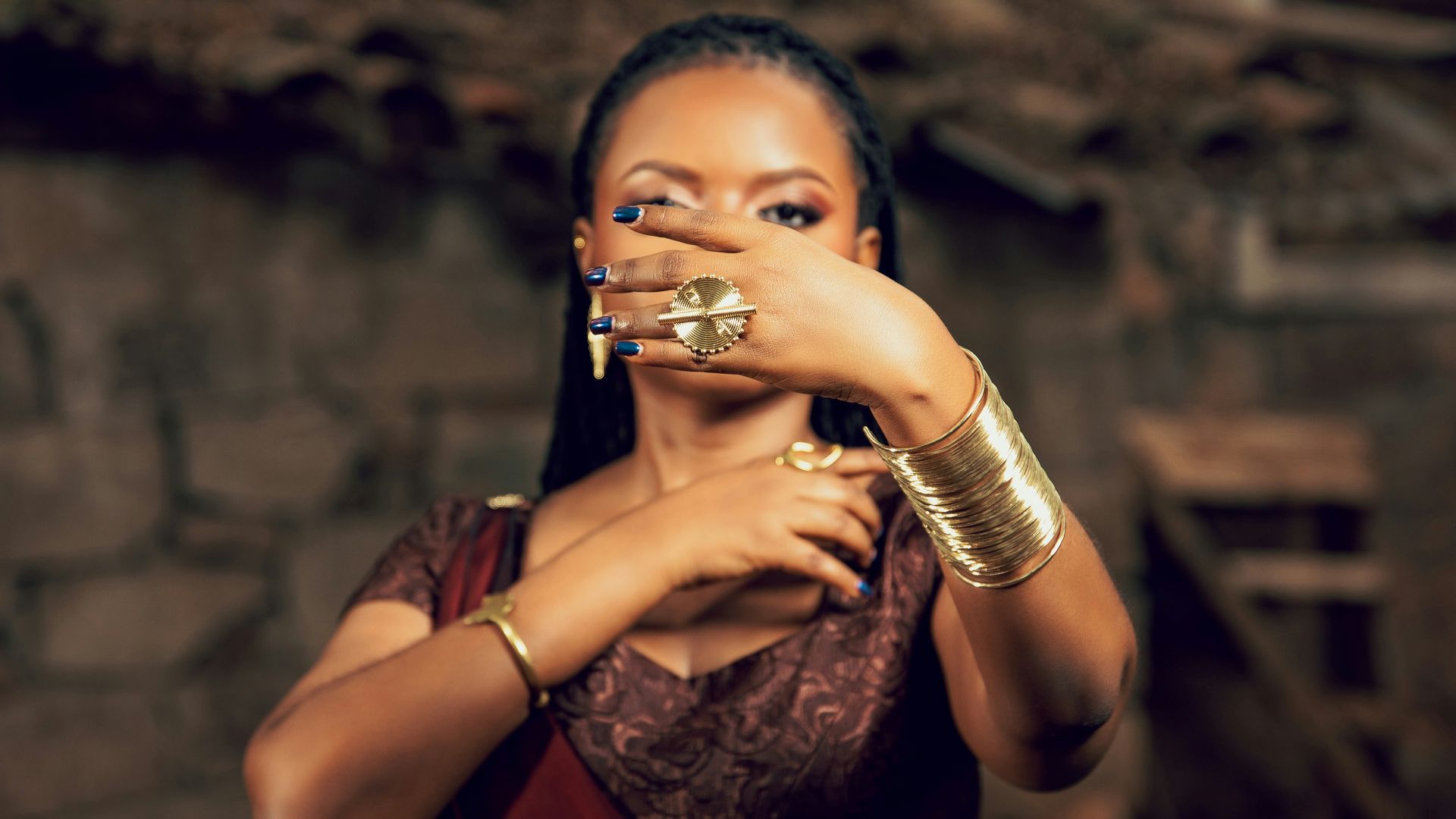 Woman in traditional dress covers face with hands.