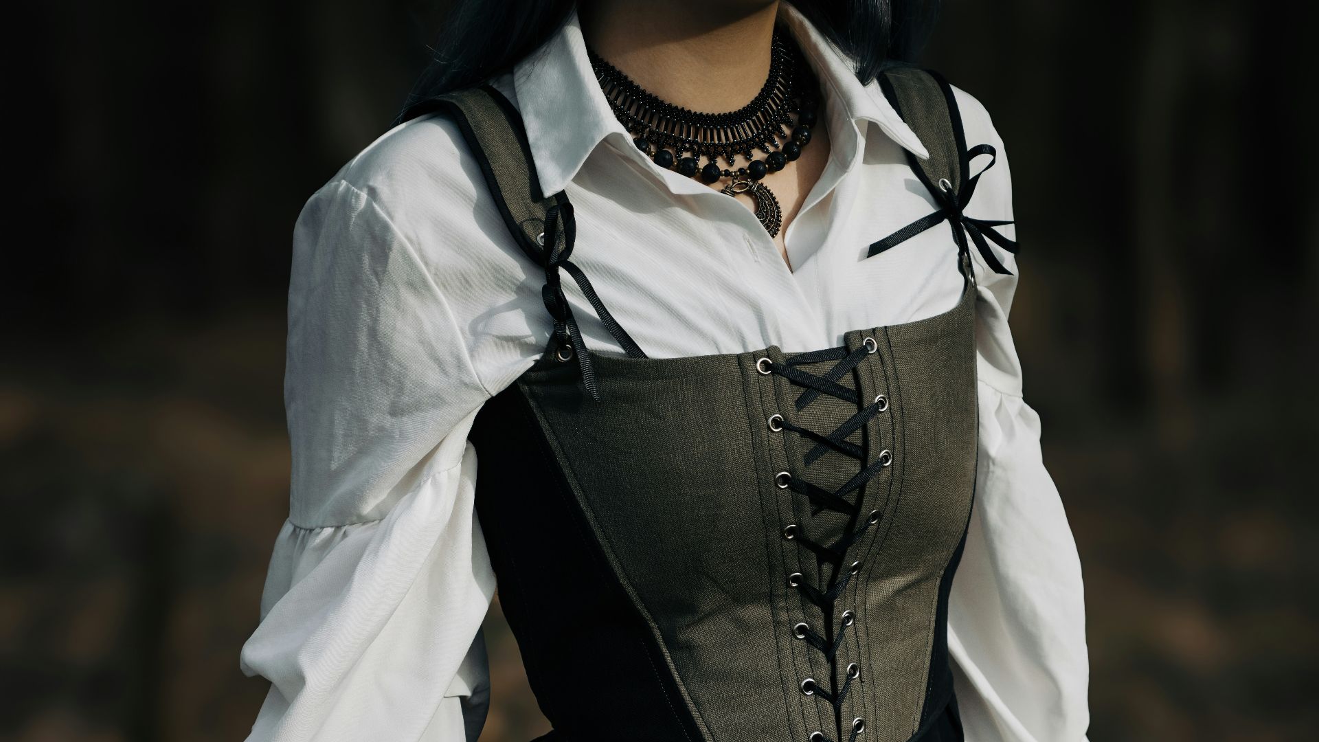 A woman in a black and white dress standing in a forest