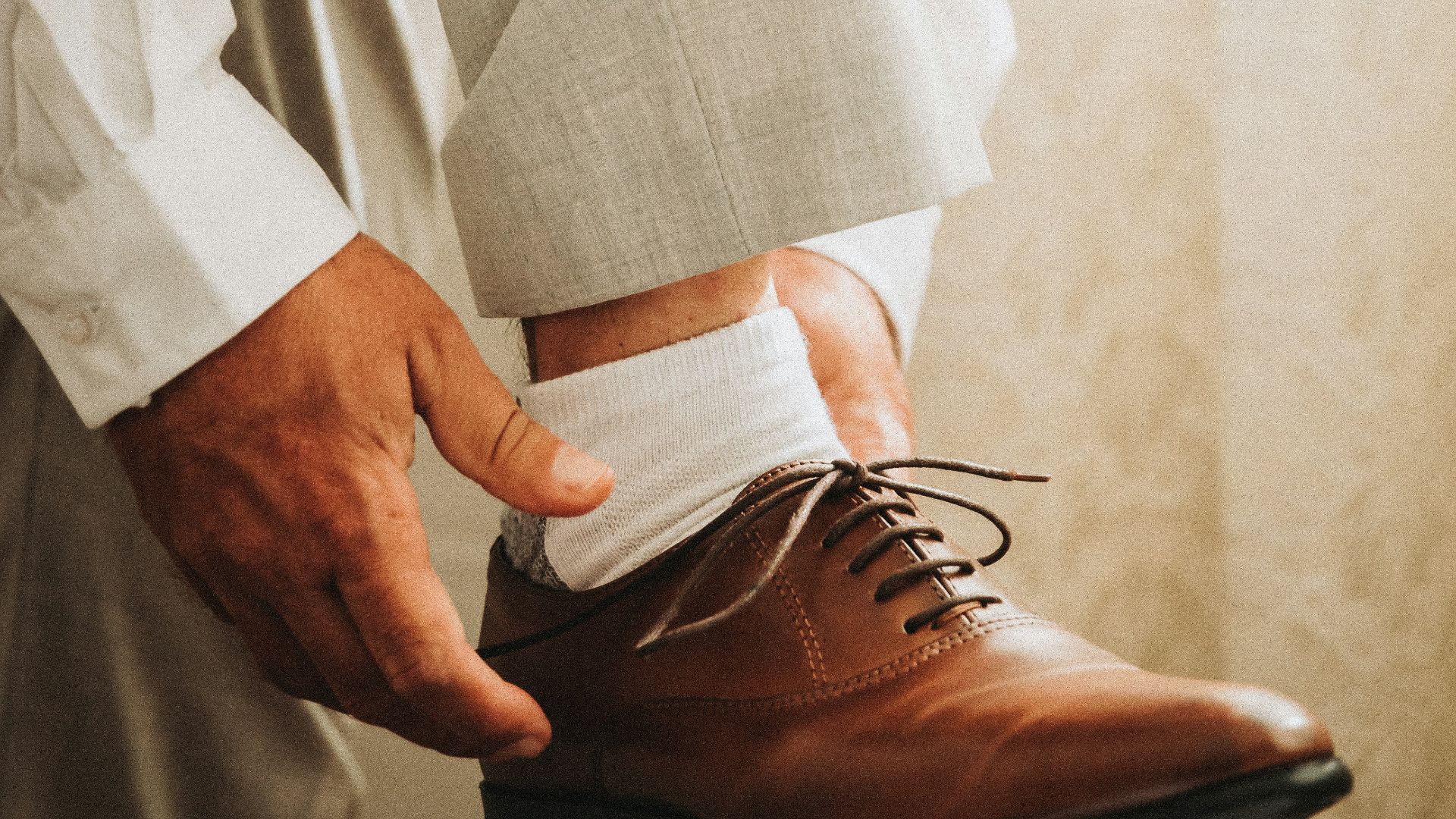 person in gray formal suit jacket wearing brown leather shoes