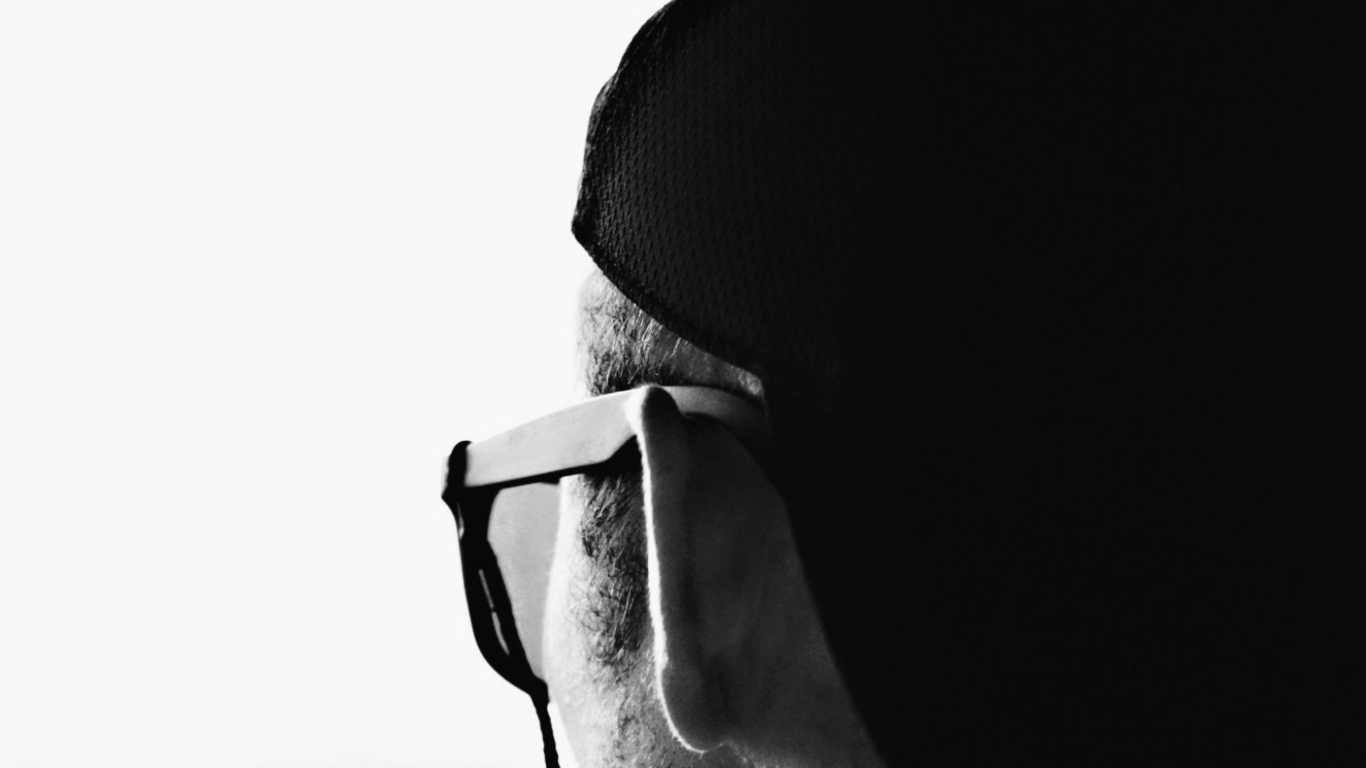 grayscale photo of woman wearing black and white stripe shirt and black framed eyeglasses