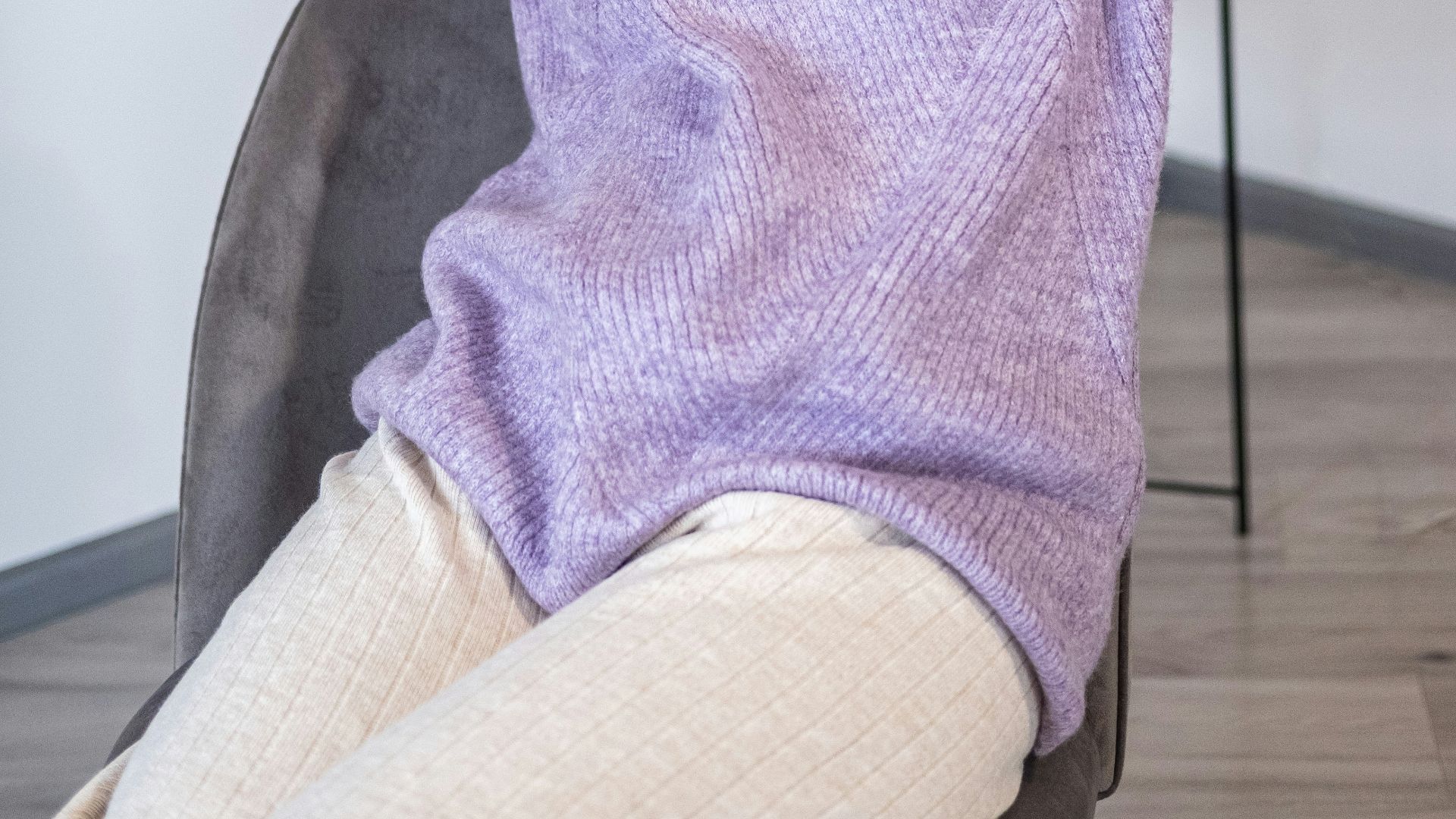 a woman sitting on a chair with her hands on her head