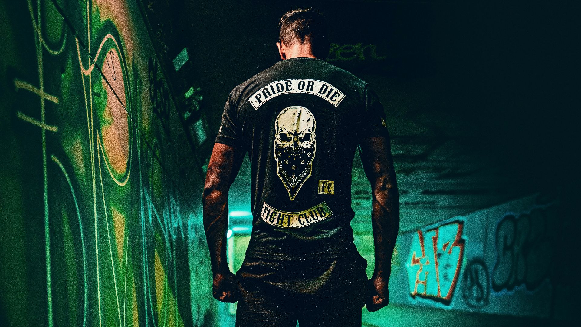 man in black and white crew neck t-shirt and blue denim jeans standing beside neon