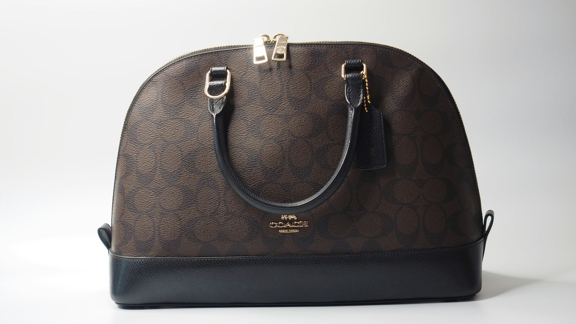 a brown and black handbag sitting on top of a white table